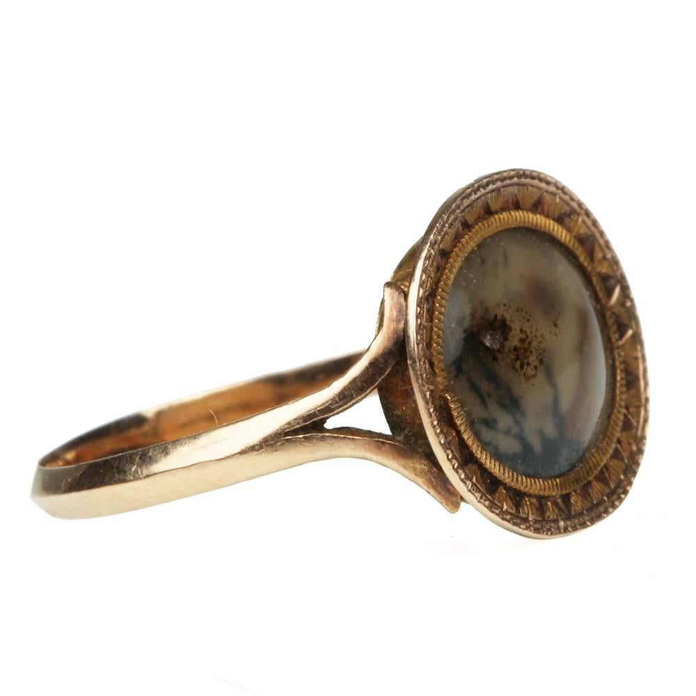 Late 19th Century moss agate ring. The agate natural patterning depicts an abstract mountain scene. The stone is set in a closed back setting with engraved detailed gold frame. English in origin. Circa 1780

Size 5. can be resized.
