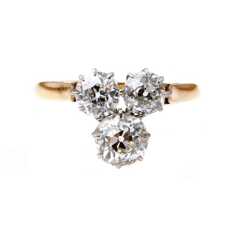 Edwardian three stone ring in the form of a trefoil.  Three transitional old mine cut diamonds with an approximate total carat weight of 1.75 carats. The larger weighing .75 carats and the two smaller, approximately .5 carats each.  Set in platinum