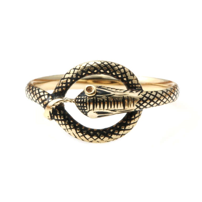 This Snake ring dates to the first half of the 19th century. Beautifully detailed enamel scales in 18k gold. European in origin, Circa 1830. Size 6.5, not sizable. 

There is a similar example exhibited at the Victoria & Albert Museum in London.