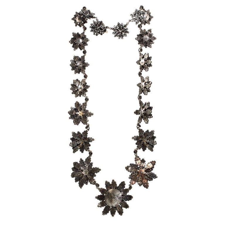 A nice example of an early 19th century cut steel necklace. 18 floral sections in descending size and a matching push button clasp make up this glittering steel necklace. Measuring a generous 17