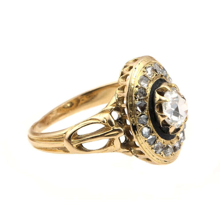 Late 19th Century 18k gold and diamond ring with black enamel details. Rose cut diamonds surround the central old mine cut diamond. Found in Paris. Circa 1870. 

Size 6.5, sizable.