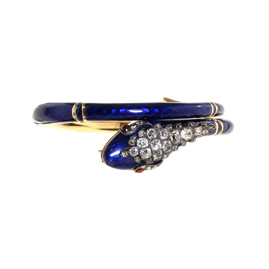 Victorian era 18k gold & blue enamel snake bracelet with multiple hinges. Old mine cut diamonds in the head and rubies for eyes. The serpent is masterfully hinged at 4 separate points allowing it to fit multiple wrist sizes. English in origin. Circa
