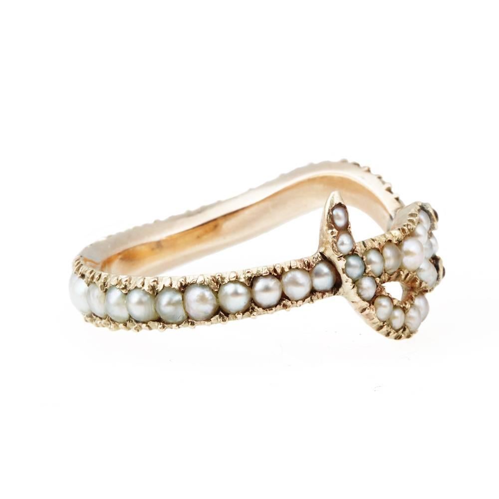 Early 19th Century natural pearl snake ring. Pearls and garnet eyes set in 18k gold. The snake was a popular Victorian-era symbol for eternal love. English in origin, Circa 1810.

 
Size 7, cannot be sized.