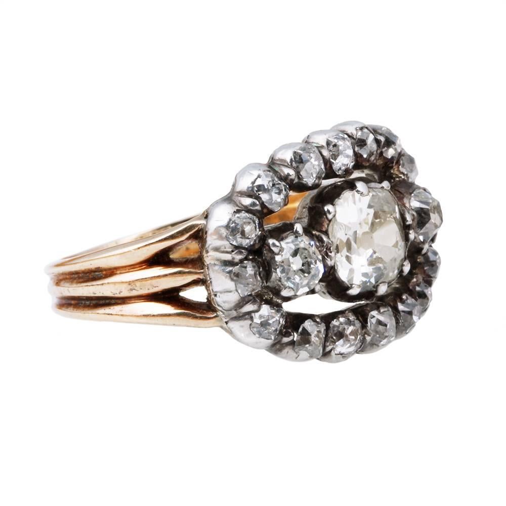 Early Victorian diamond ring. Three larger old mine cut diamonds surrounded by additional old mine cut diamond. Approximately 1.25 in total carat weight. Central old mine cut diamond weighing approximately .50 carats. The diamonds are set in a