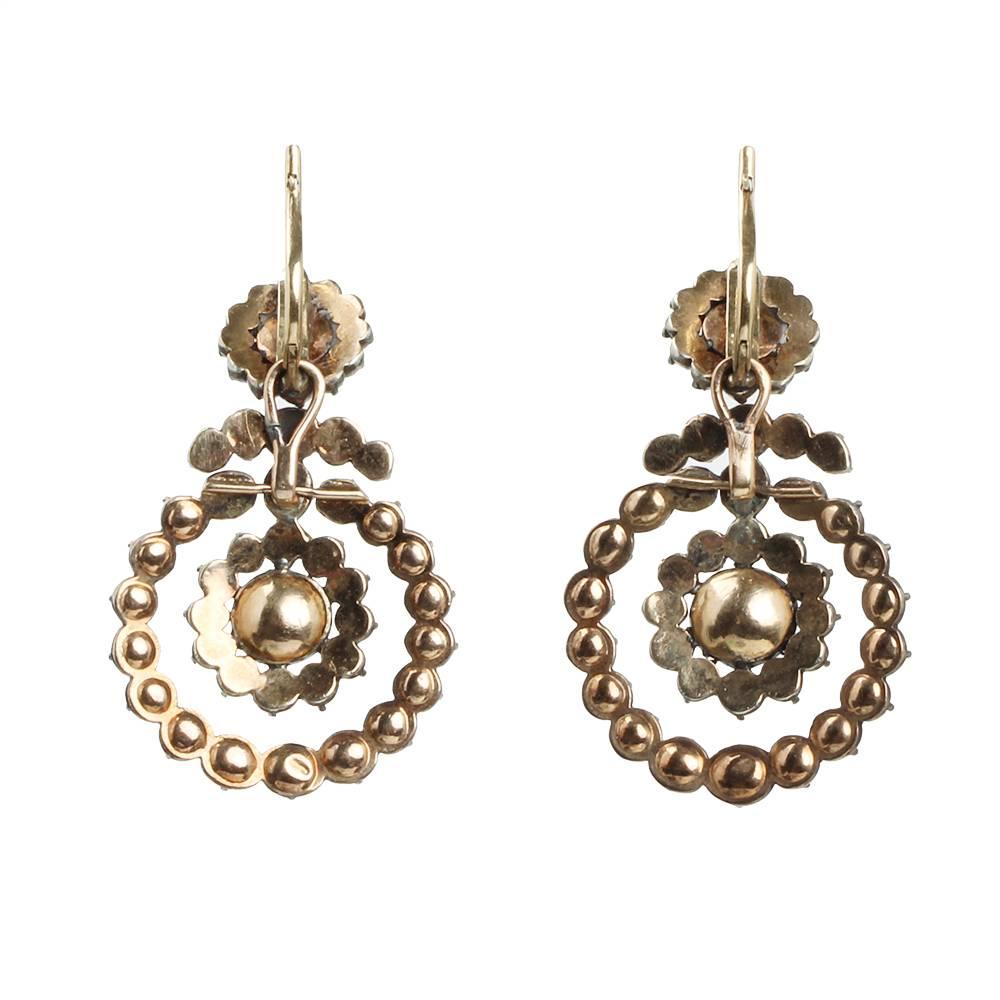 Georgian rose cut diamond earrings with interlinked dangling rings. Gold earring post with hinged backs. English in origin, circa 1820. 

2