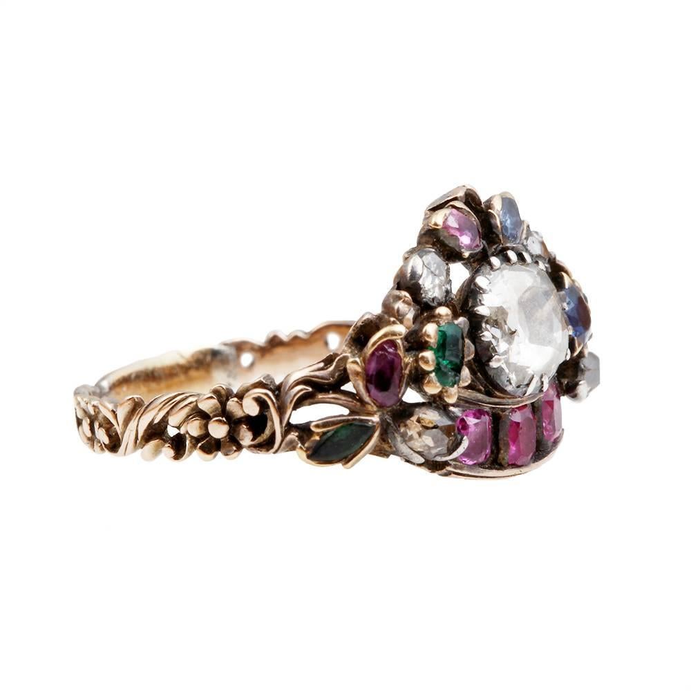 Mid 18th century giardinetti ring. Of unusual design mounted with a central collet set diamond and variously mounted throughout with rubies, sapphires and emeralds. Of asymmetric design. Western European. Circa 1750.

Size 6.5, can be resized.
