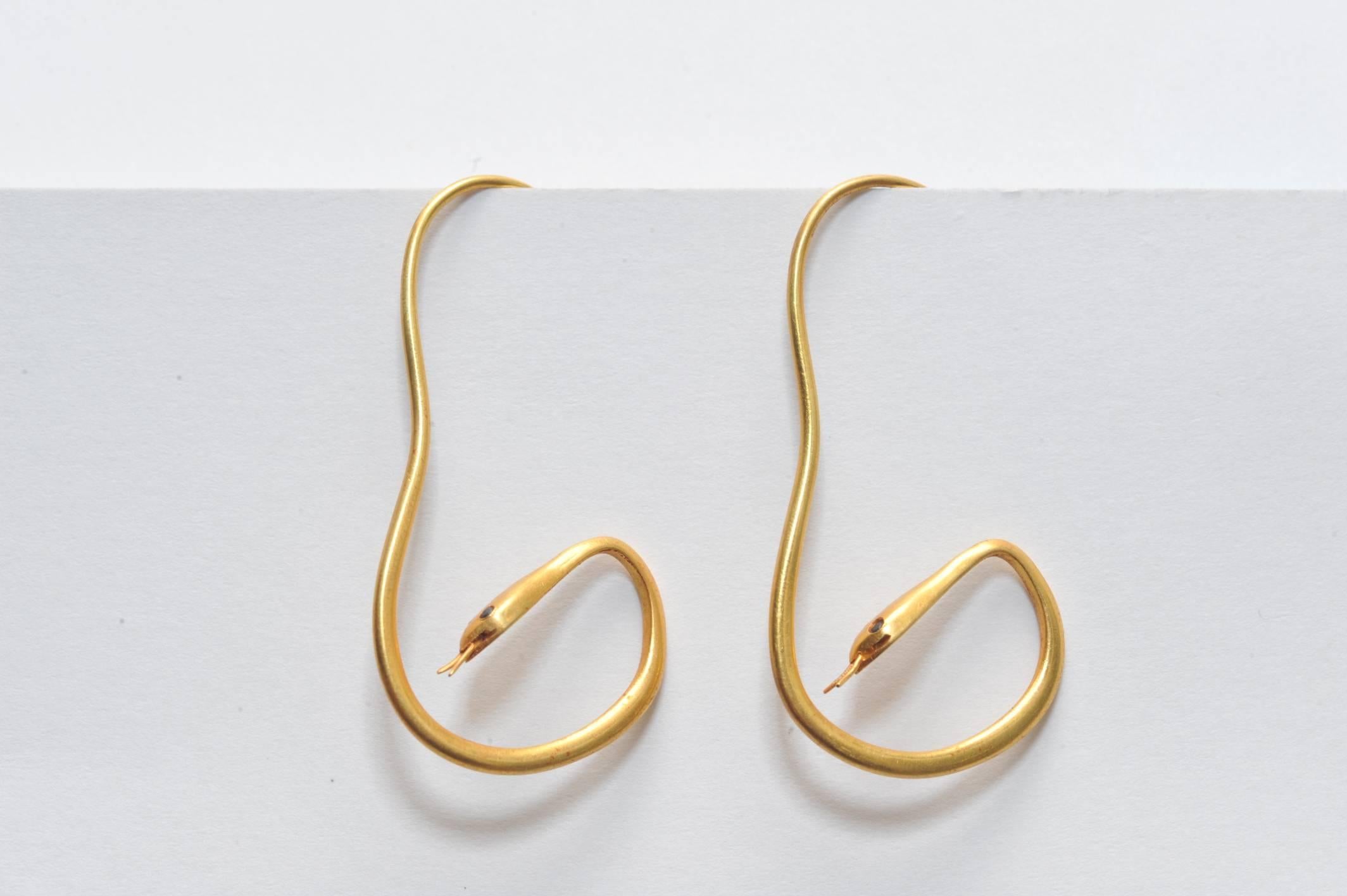 Pair of 22K Gold snake earrings with sapphire eyes in the shape of a quasi hoop.  Complete with forked tongue.  Simple wire back.