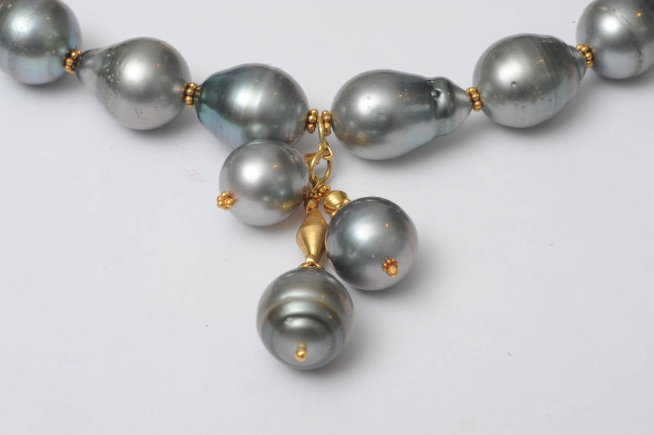 A sexy strand of 12-15 mm Tahitian pearls with 18K gold spacers and a 3-cluster drop and 18K gold chain across the back to allow for length variability (16.5 - 18 inches;).  The tahitians are a very nice size and irregularly shaped which adds to