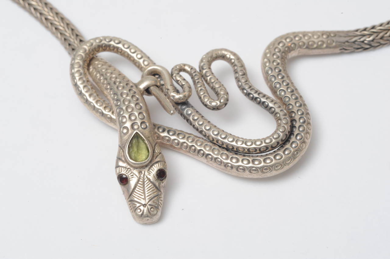 Supple, hand-woven sterling silver snake chain with peridot third eye and garnet eyes.  Clasps in front.  Contemporary.

Fine Jewelry, Nantucket, MA