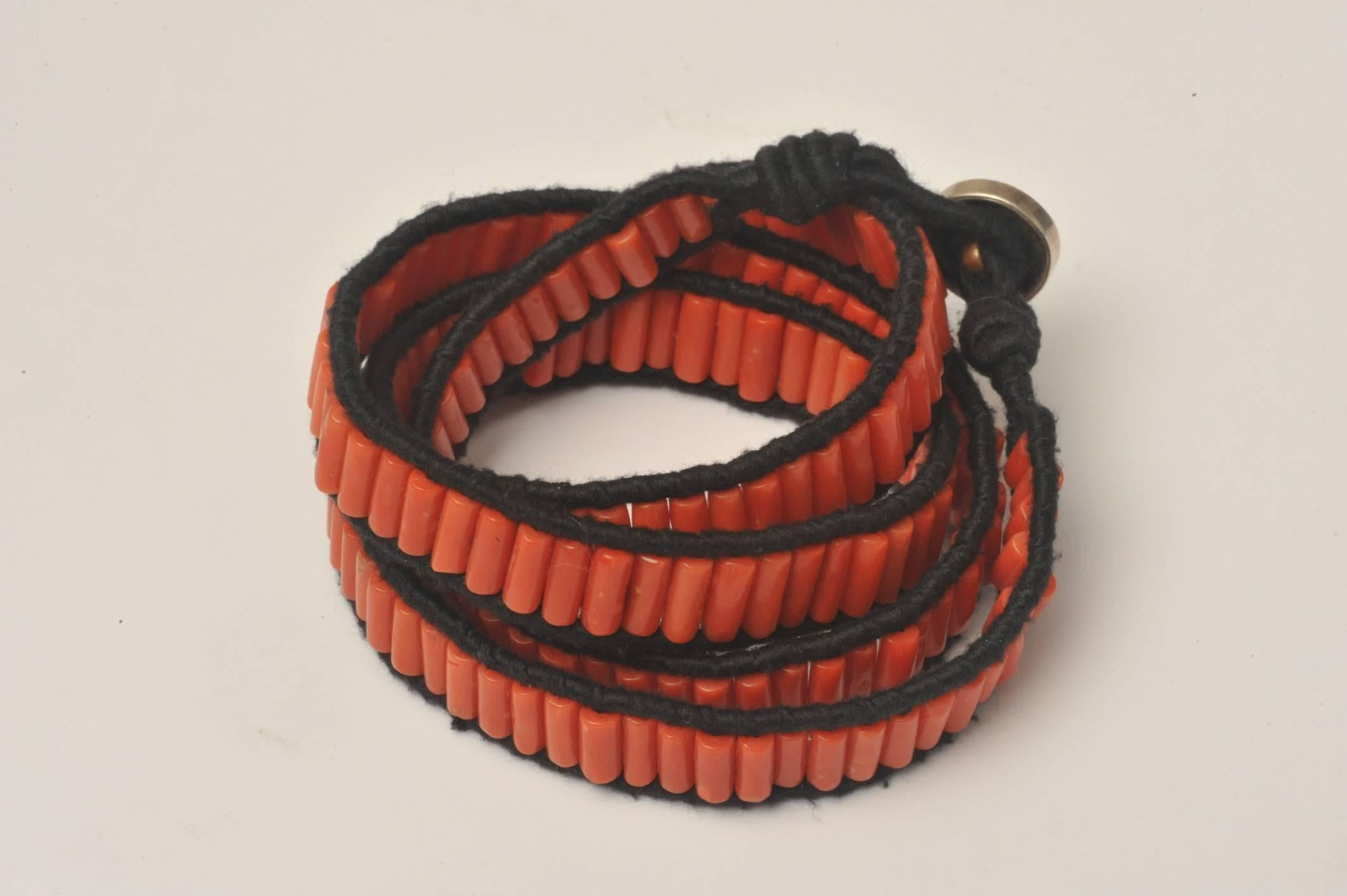 Great quality coral beads in a back cotton wrap bracelet.  Has a sterling silver and copper button clasp.