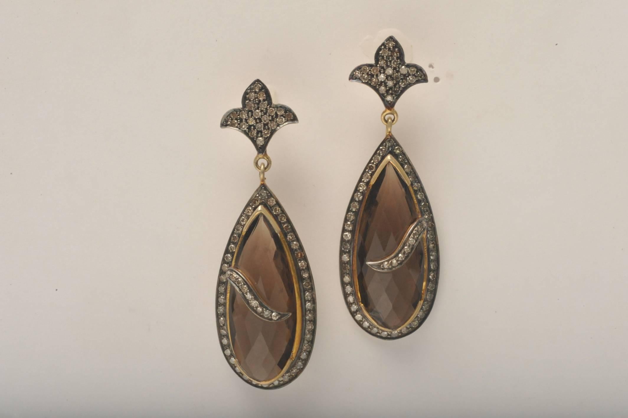 Pair of unusual faceted smokey topaz pear-shaped earrings with pave`-set diamonds set in 18K gold and sterling silver.

Smokey topaz carat weight is 23.45
Diamond weight is 1.98