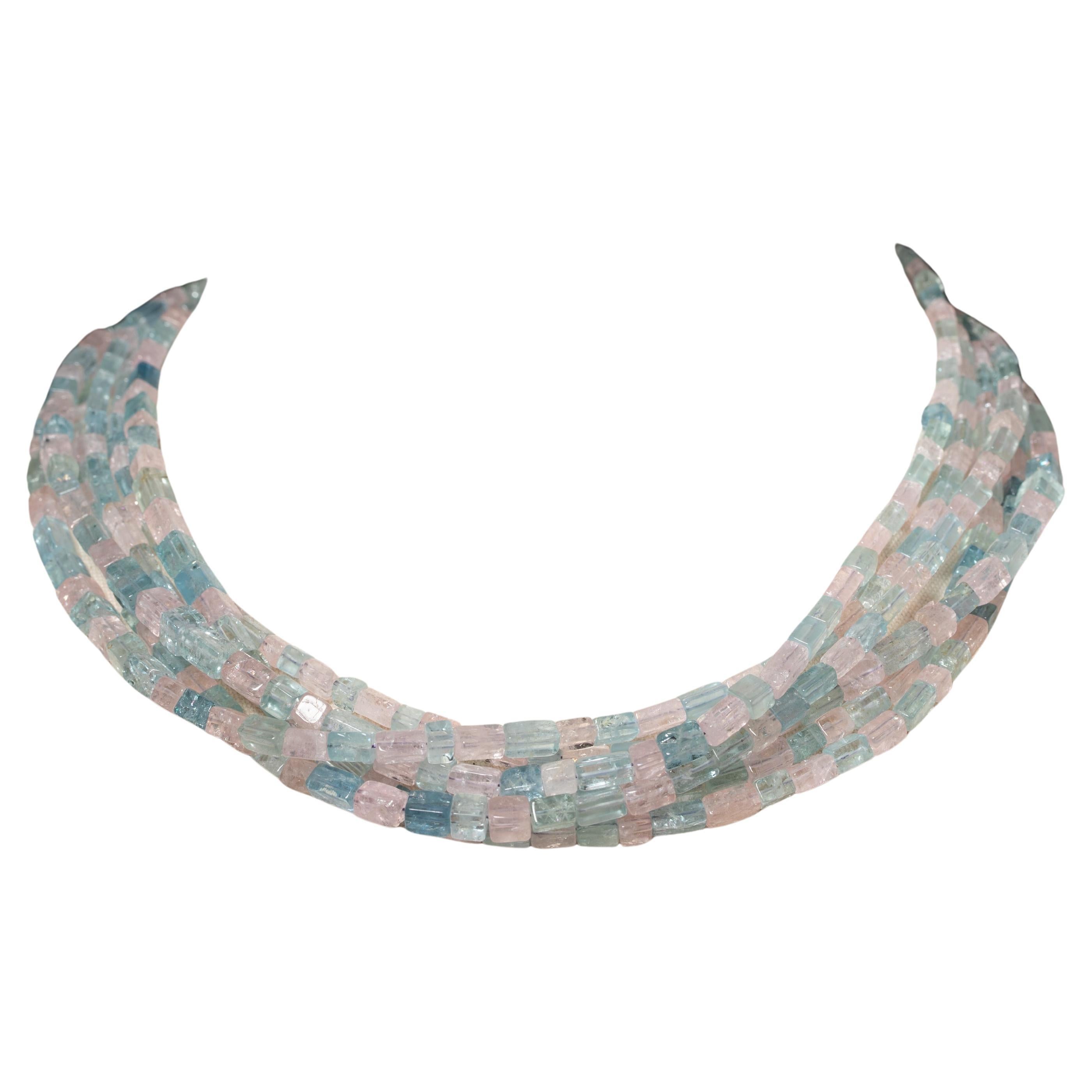 A long triple-strand or doubled six-strand necklace of beveled aquamarine and morganite (which is a pink aquamarine given that it is in the same beryl family).  With a pave`-set diamond clasp and end-caps set in an oxidized sterling silver, which
