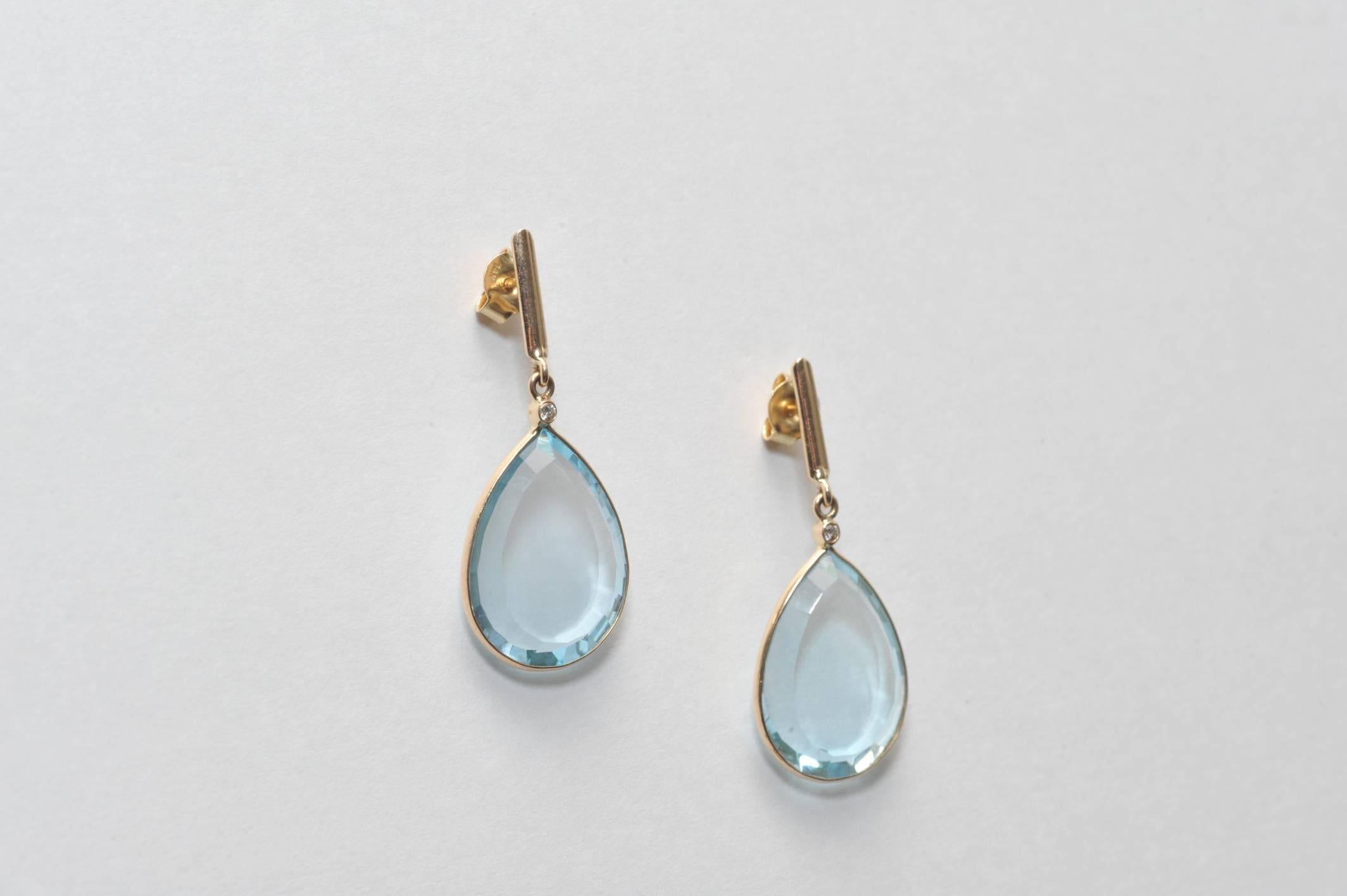 Pair of lovely pear-shaped aquamarines with bevel-cut edges set in 18K  gold and faceted diamond at the top.  For pierced ears.  Carat weight of the aquamarines is 24.34.  Classic style.
