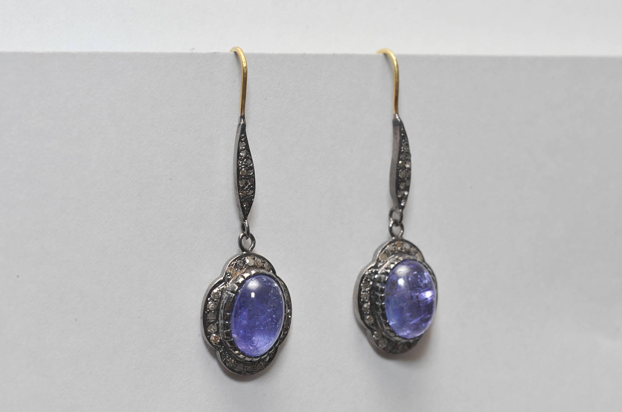 Pair of cabochon tanzanite earrings bordered with pave`-set diamonds set in oxidized sterling with 18K gold French wire.  Tanzanite is 8.9 carats and diamonds are .48 carats.  