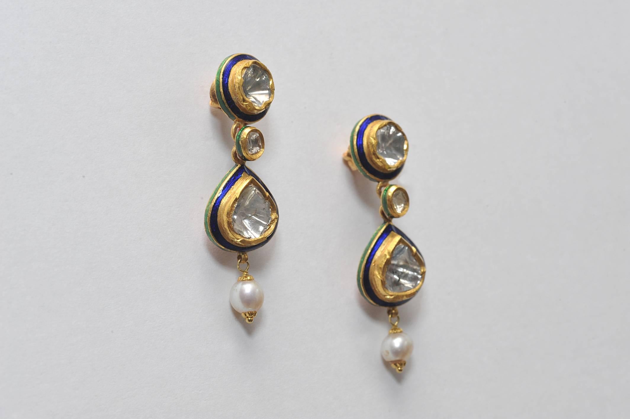 Beautifully crafted pair of rosecut diamonds set in 22K gold with kundan enamel work along the edges and along the backside with a drop pearl.  Indian made, late 1900's.  2.4 carats of diamonds.  

Rare and unusual pieces of fine Indian jewelry.