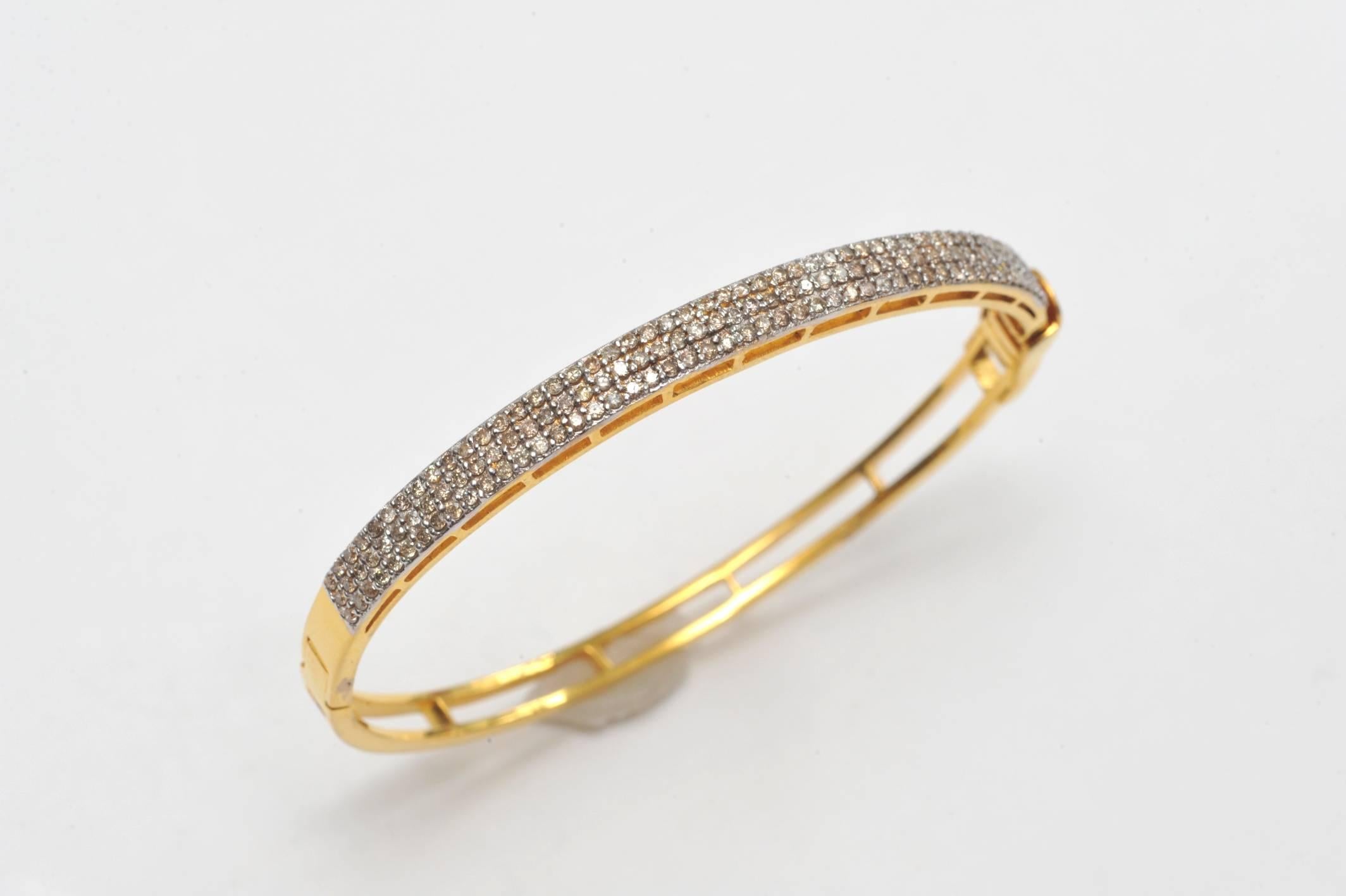 Lovely, triple-row of pave`-set diamonds set in 22K gold.  Oval shape ensures the stones stay on top of the wrist.  Carat weight of diamonds is 1.54.  Simple and elegant.  Inside circumference is 6.25 inches.  Hinged with locking push clasp.