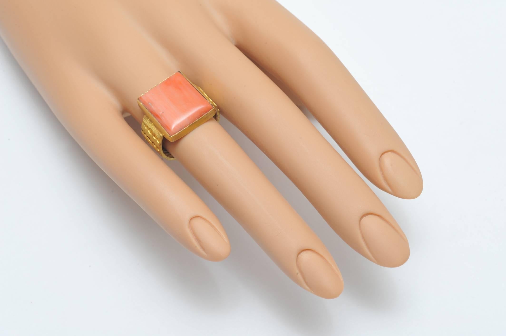 Square cut Italian coral ring set in a 22K gold textured band with fine and intricate tooling.  Coral is 10 carats.  Ring size is 6.5.   Stone size is 9/16 x 5/8.