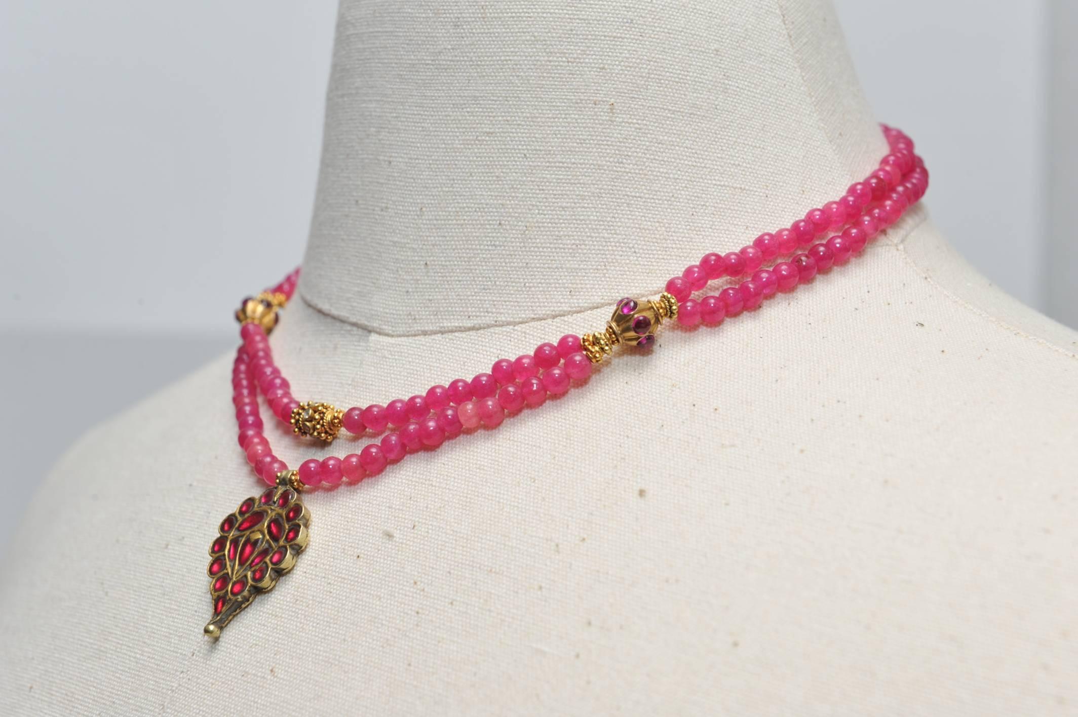 A double strand of round, pink Burmese ruby beads, with pink spinels set in the 22K gold pendant and again in the gold beads at the collar bone.  Faceted round, brilliant cut diamond rondelle sits on the upper strand above the pendant.  Ruby set in