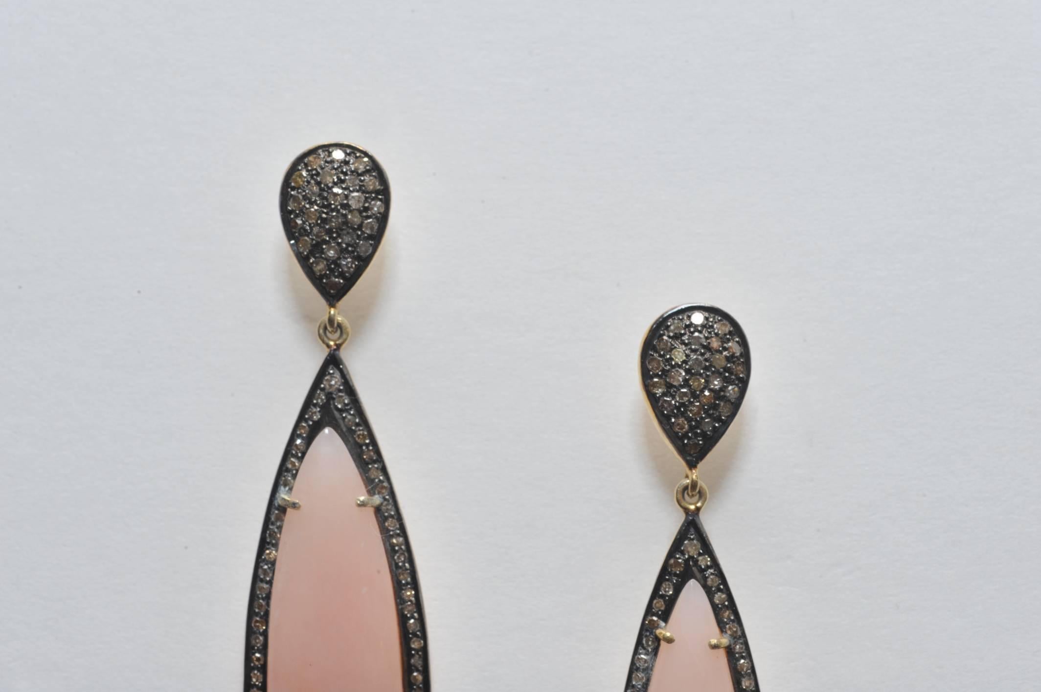 Pair of oval shaped pink opal drop earrings bordered with pave`set diamonds and diamonds on the post.  Set in oxidized sterling with 18K gold post for pierced ears.  
