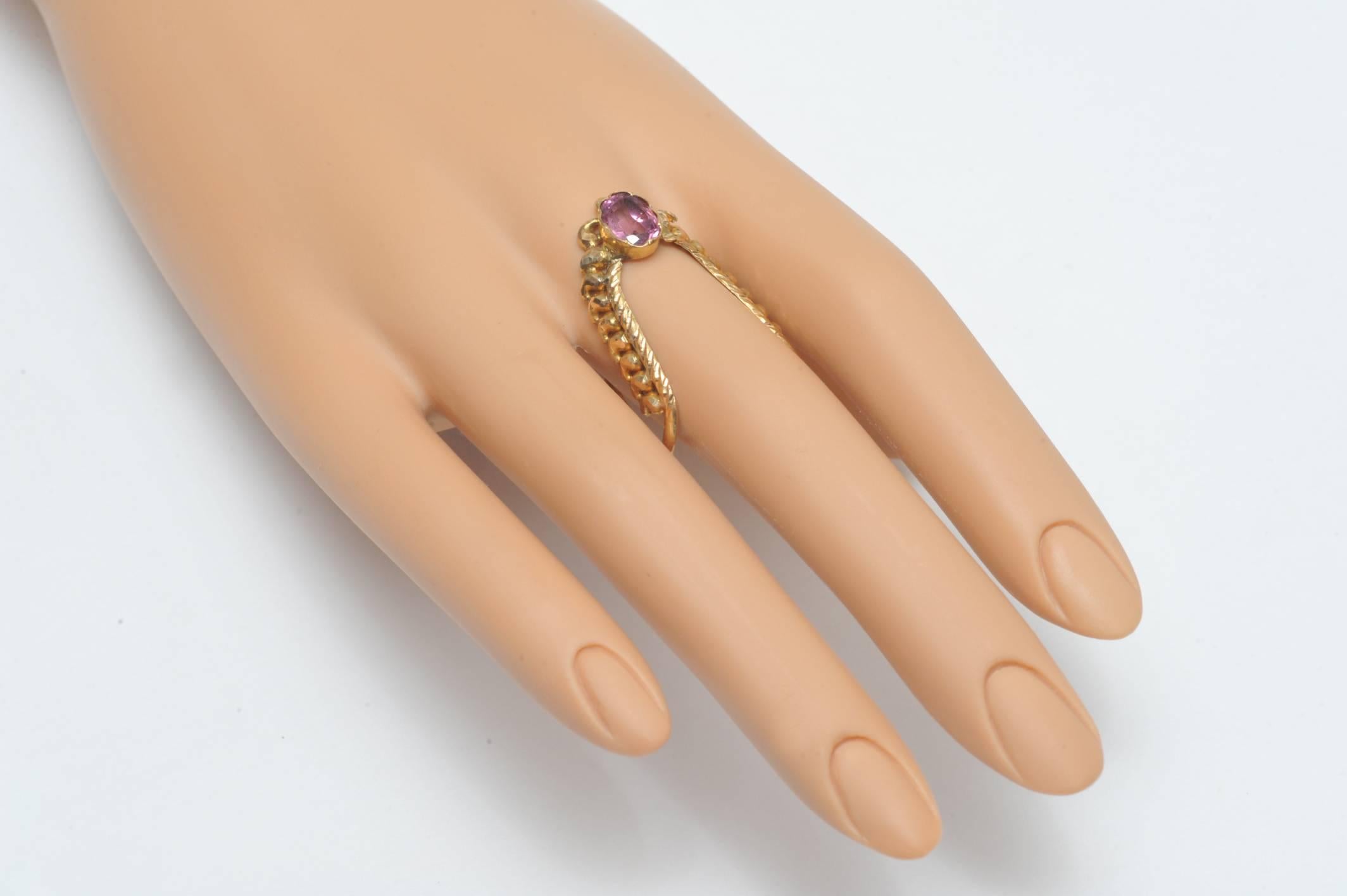 A very unusually-shaped ring with intricate 18K gold work and a faceted oval pink tourmaline.  The design allows for some size flexibility and looks great as a thumb ring as well.  Size as is would be 7.75 at the largest part. Tourmaline is 1 carat.