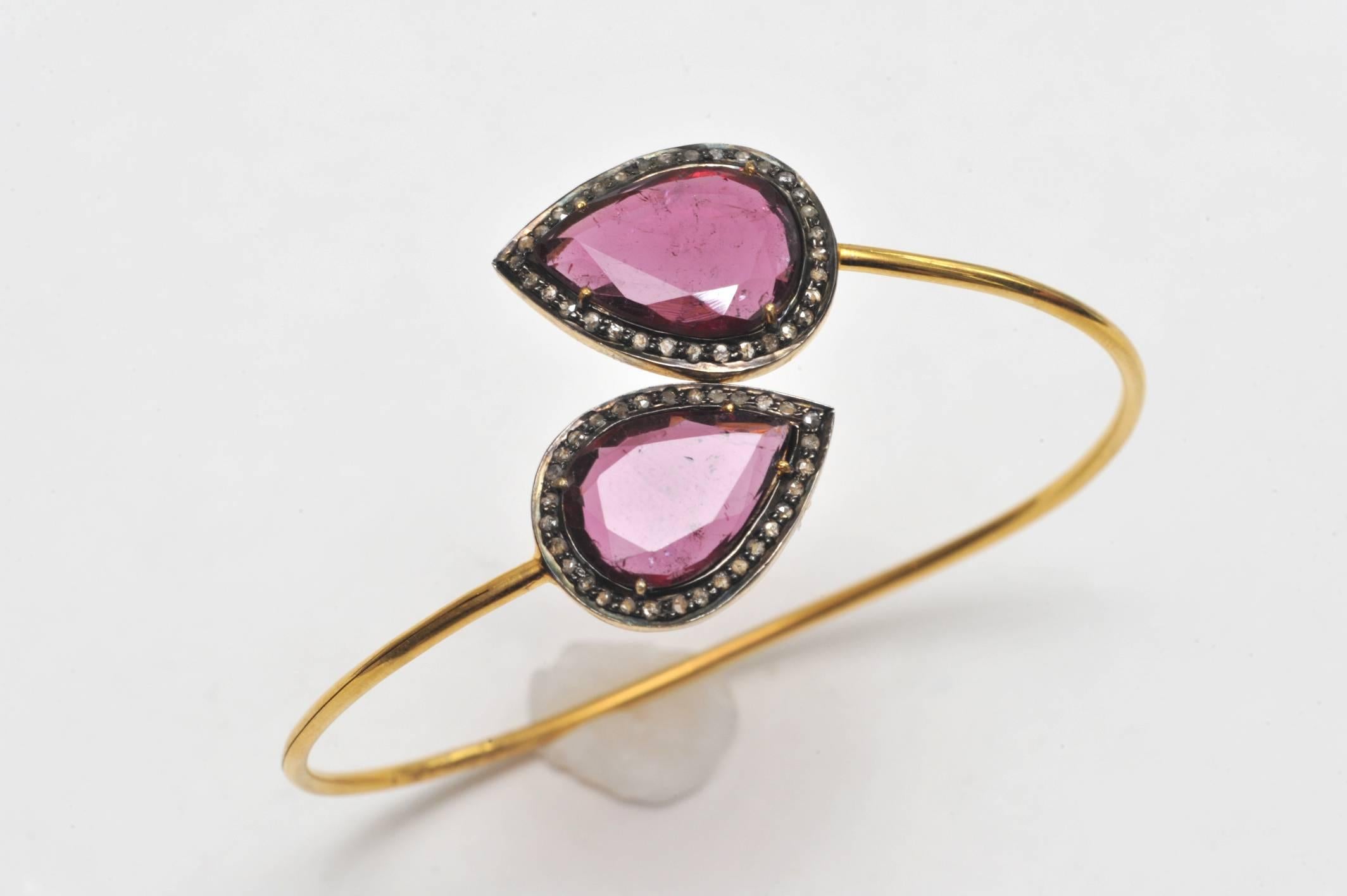 Lovely pear-shaped, faceted pink tourmaline 18K gold wrap bracelet bordered in pave`-set diamonds.  The bracelet has flexibility making it easy to get on and off and is oval shaped enduring that the stones remain on top of the wrist.  Carat weight