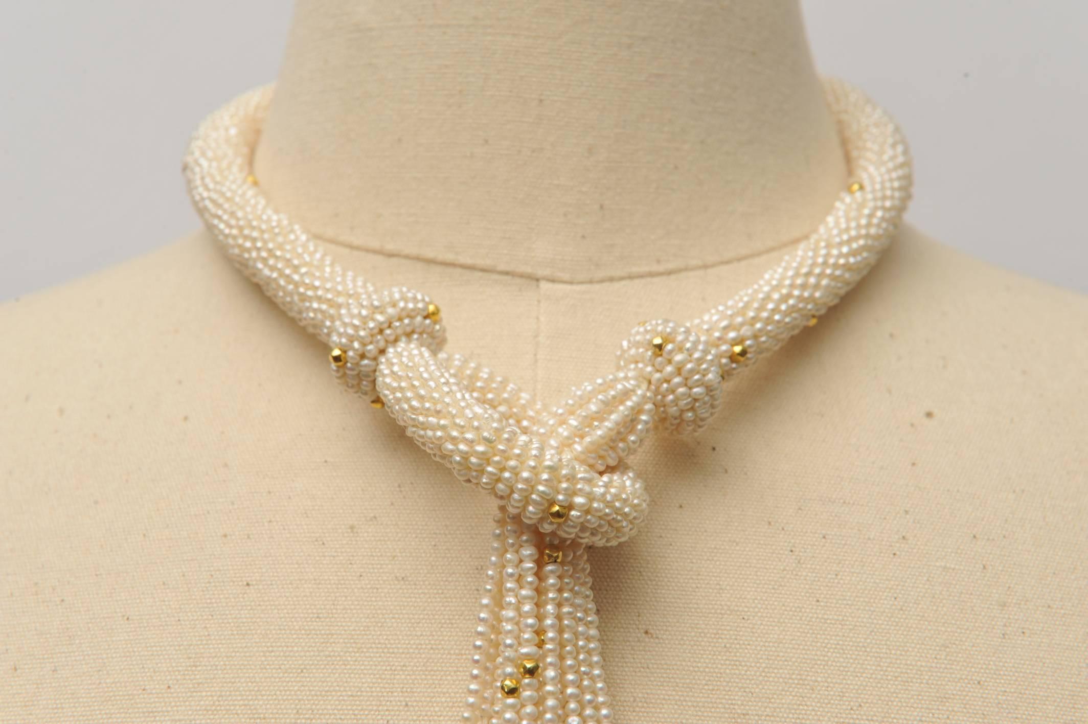 Incredible and stunning hand-woven lariat necklace made of 24 strands of seed pearls interspersed with 18K gold beads. An unusual and intricately made statement piece which can be worn a number of ways.  Just the loop section is 17.5 inches,, tassel