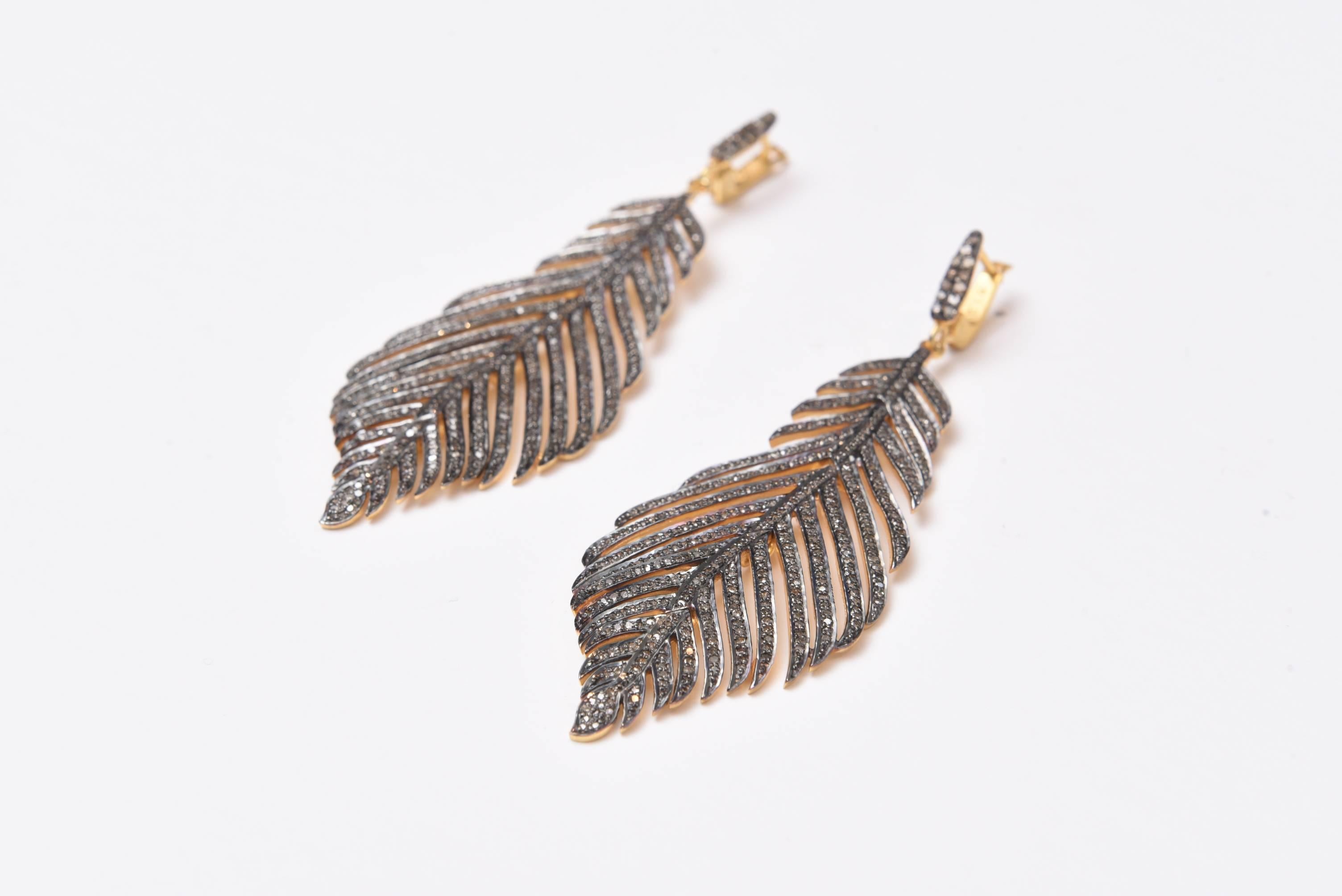 Lovely pair of earrings with pave`-set diamonds in 18K Gold and sterling.  They are hinged along the back spine in four different places to create movement.  An 18K gold post, for pierced ears.  Carat weight of diamonds is 3.22


Located on