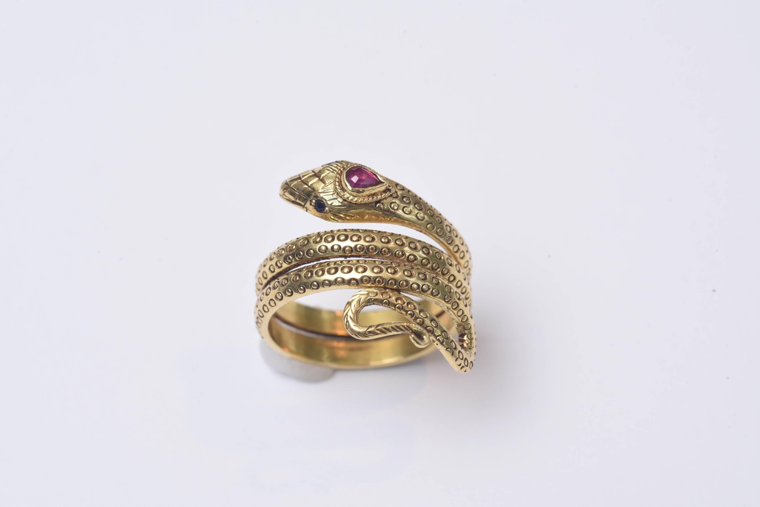 Finely tooled 18K gold snake ring with faceted blue sapphire eyes and a faceted pear-shaped ruby third eye.  Some flexibility to sizing, as is it is a size 7 3/4.