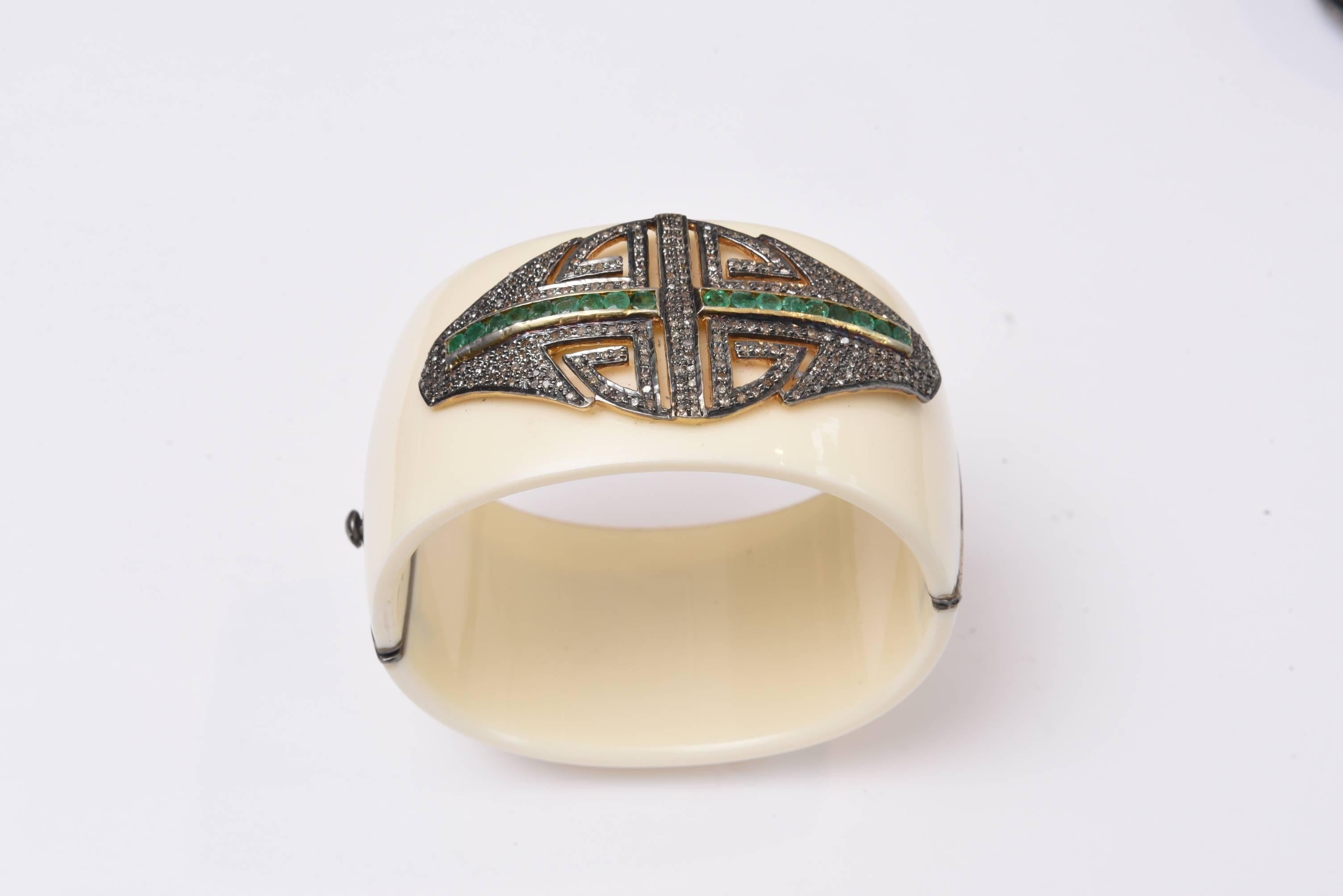 Unusual cuff bracelet of pave`-set diamonds and channel set emeralds in an art deco design in sterling silver affixed to a bakelite cuff.  Hinged for easy on and off and an slightly oval shape to keep the stones on top of the wrist.  Inside