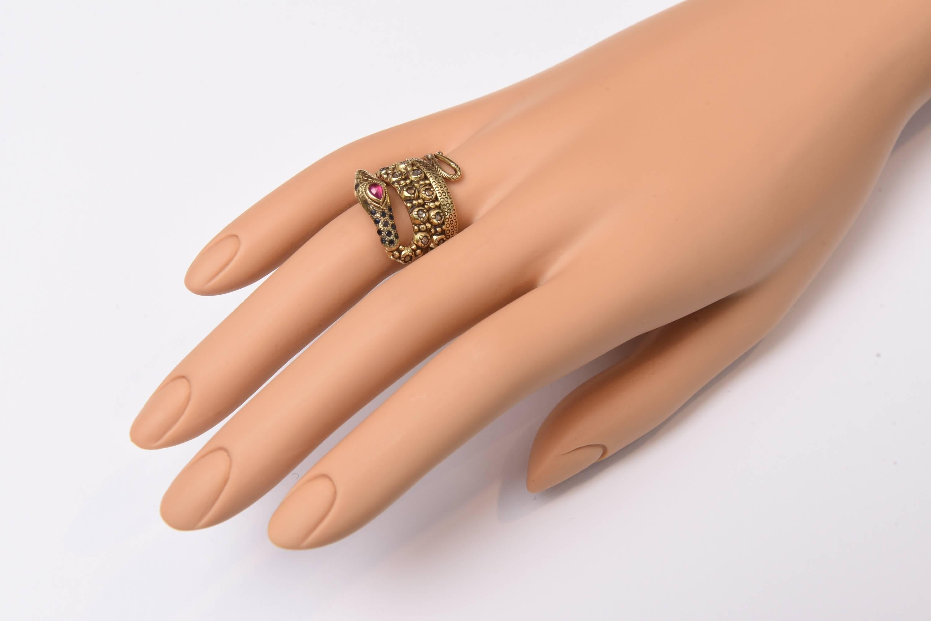 18K gold coil snake ring with faceted diamonds around the band, pave`set sapphires at the neck and eyes, and a pear-shaped faceted ruby for the third eye.  Lovely granulation work and hand-tooling.  Ring size is 7.5.