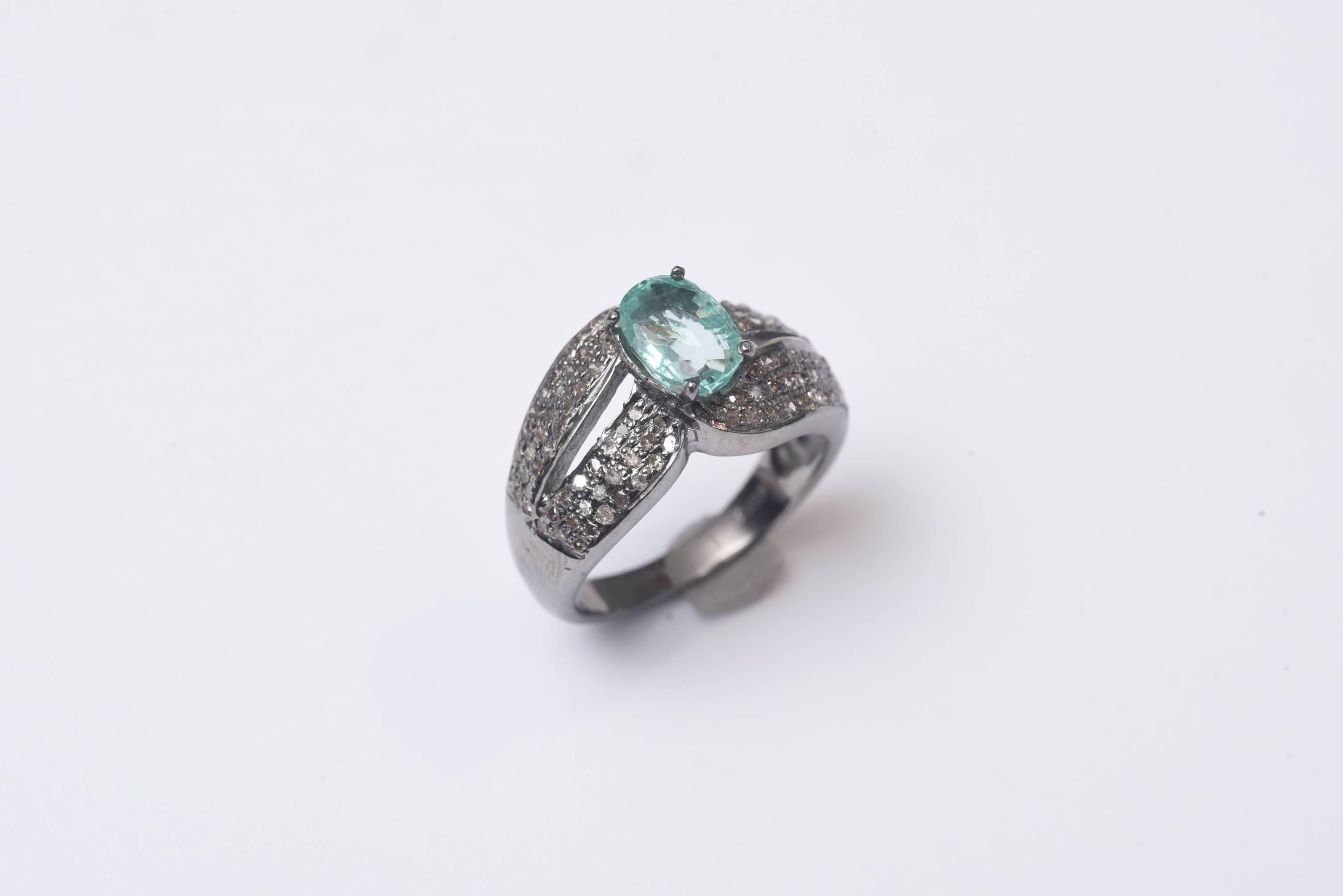 Large oval faceted blue aquamarine with pave` set diamonds along the top of the band, set in oxidized sterling silver.  Carat weight of aquamarine is 1.25, diamonds are .74 carats.  Ring size is 6 3/4.