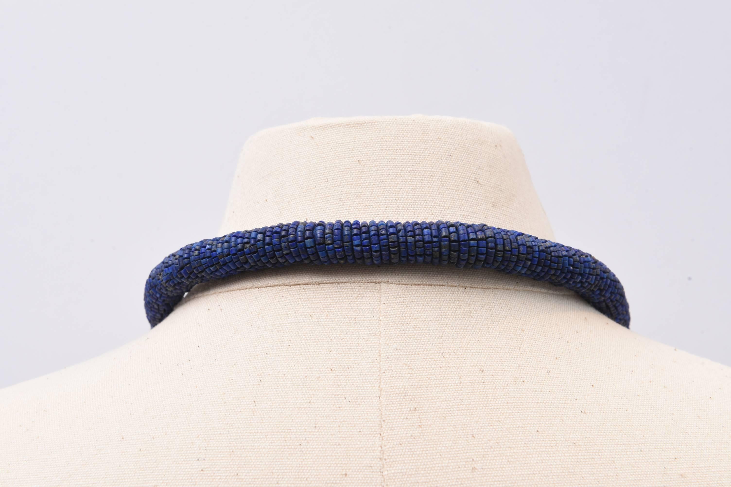 All hand-woven lapis lazuli beaded necklace with textured sterling silver beads at the collar bone.  30 strands fall below the beads.  All natural, great color lapis.  Inside circumference is 35 inches.