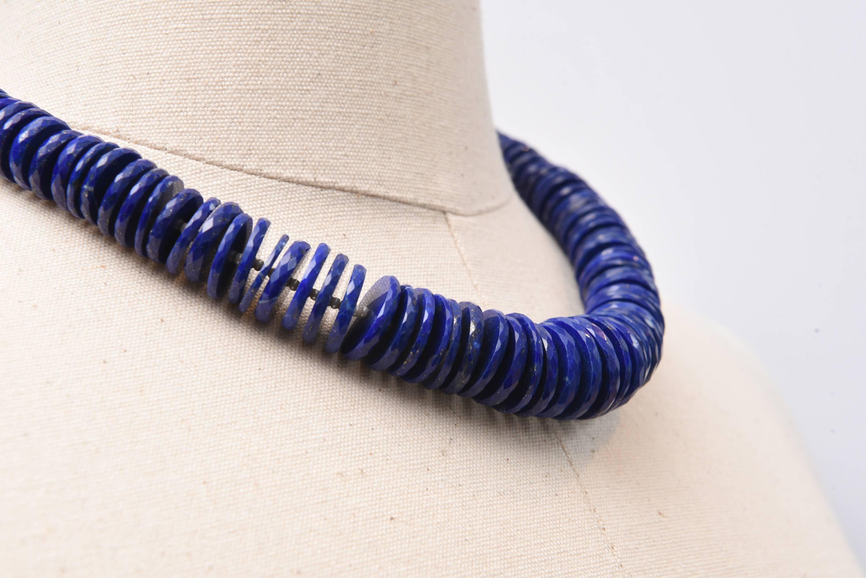 These are very unusual beads....natural lapis lazuli shaped like a saucer or a roundel and then faceted along their edge, separated by small sterling silver beads to give them space.  Graduated.  Excellent cobalt color.  The chain along the back can