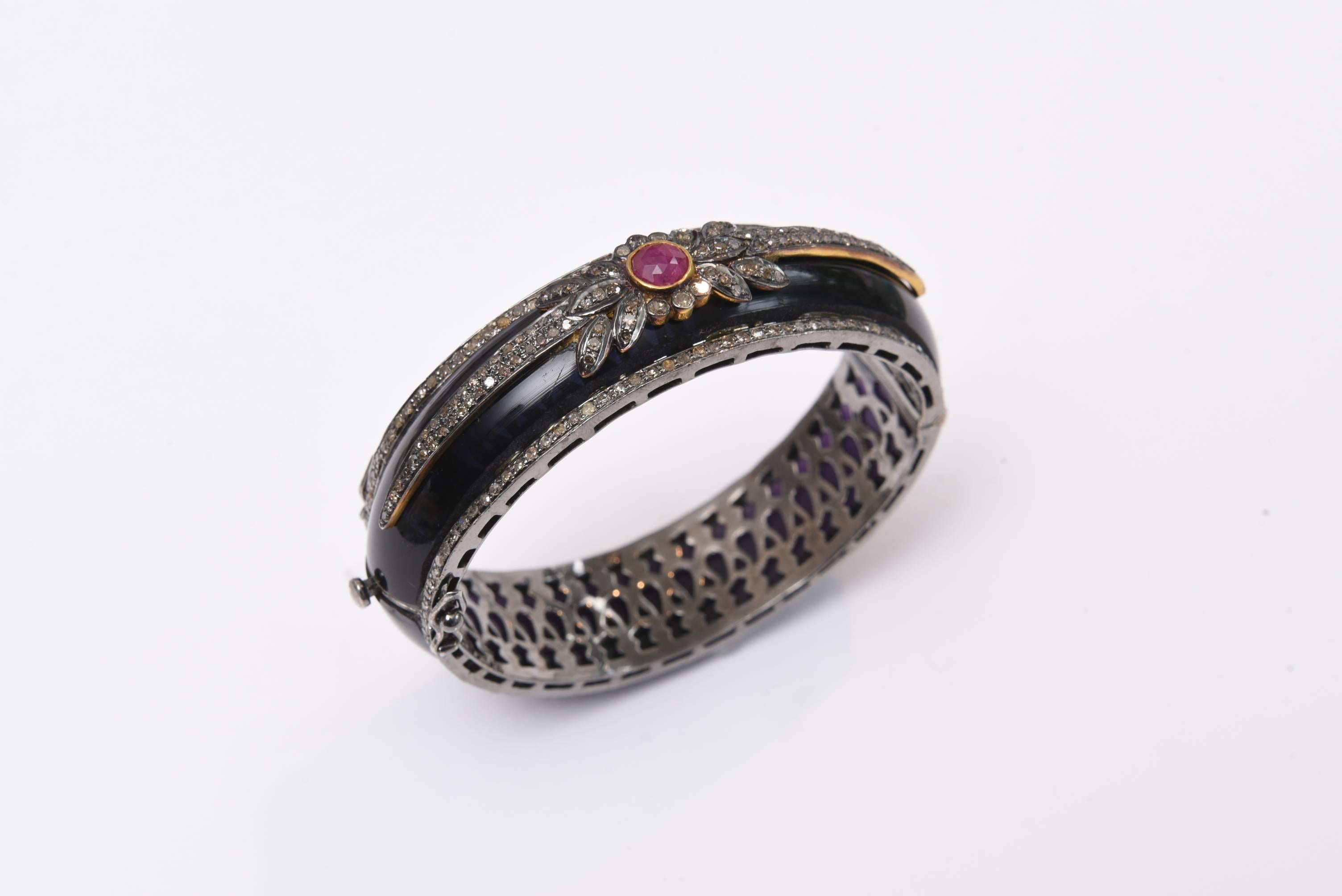Black bakelite cuff bracelet with a border of pave` set diamonds and a lovely design of diamonds and faceted ruby on the top, set in sterling silver.  It's an oval shape which is great as it keeps the bracelet from turning around. Carat weight of