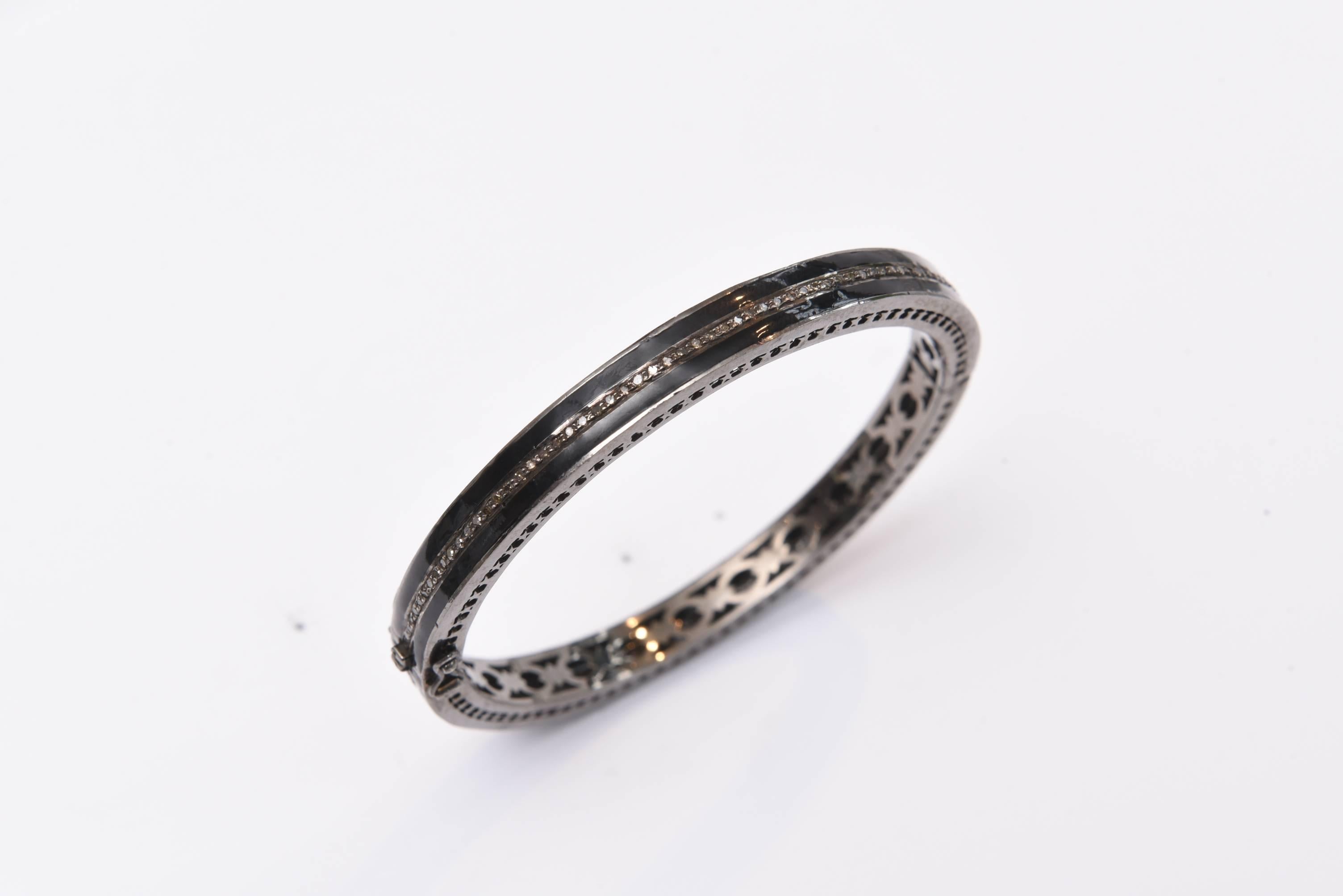 Black enamel bangle which opens, bordered in oxidized sterling silver with diamond running through the middle.  Push clasp with two safeties.  Carat weight of diamonds is 1.15.  Inside circumference is 7 inches.

