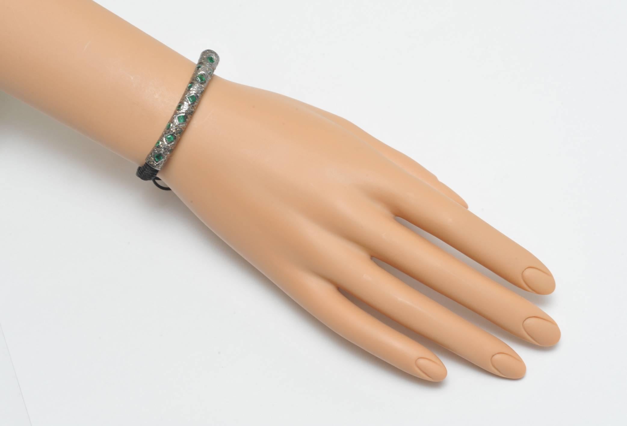 Now this is a cool thing.  emeralds  and diamonds set in sterling silver on a woven cotton adjustable band.  Go anywhere type of bracelet.  Carat weight of emeralds is 1.69  , Diamonds are 1.54 carats.  Smallest size circumference is 5.75 inches.  