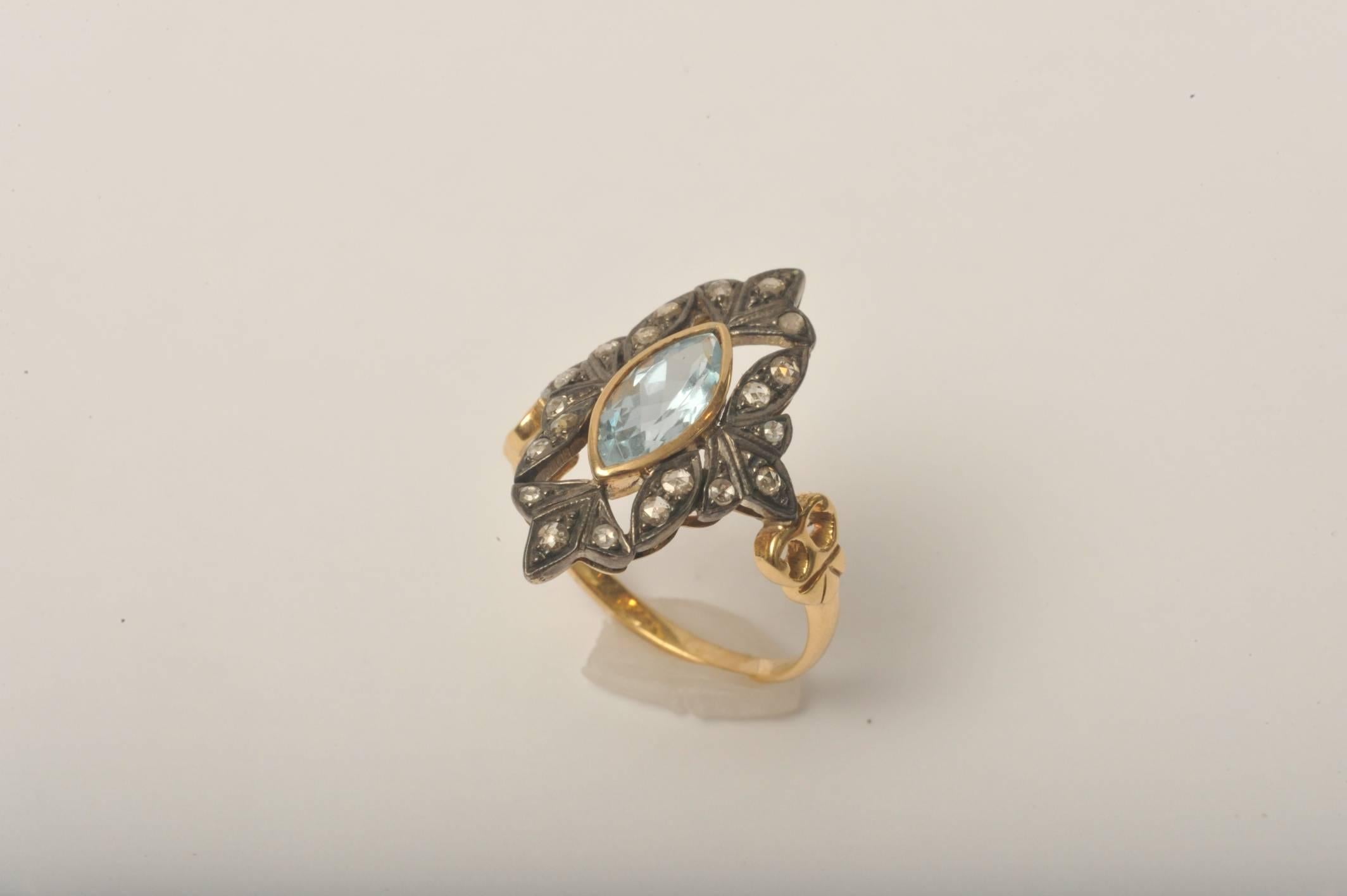 Marquise faceted center stone in aquamarine bordered in 18K gold. Great clarity and quality to the stone.  It is surrounded in round, brilliant cut, pave`-set diamonds set in an oxidized sterling silver with an 18K gold band.  Carat weight of the