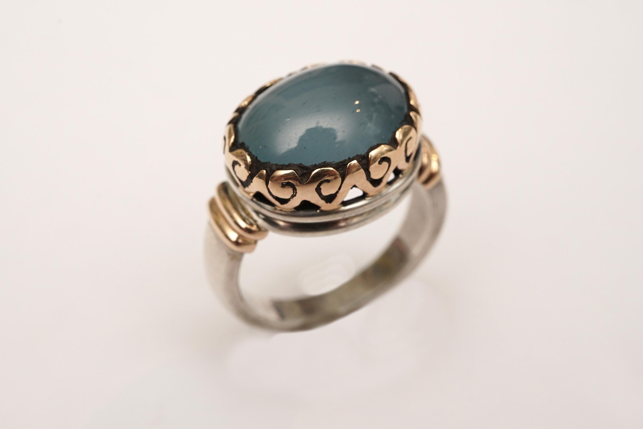 A large cabochon aquamarine in an usual and beautiful 18K gold bezel setting (not plated) and sterling silver band. Ring size is 7.