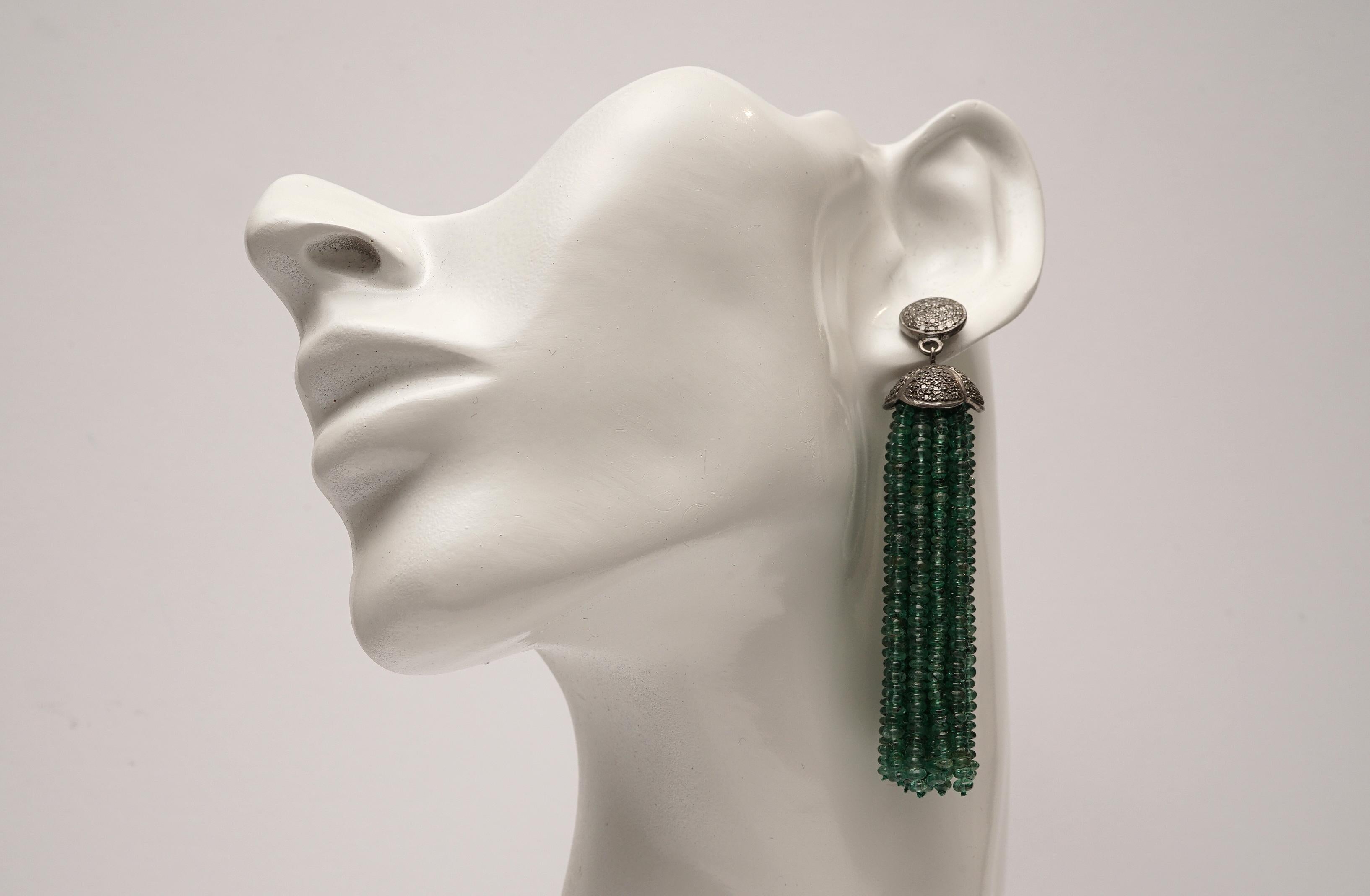 A tassel earring of 18 lines (each) of faceted Zambian emeralds with sterling silver end caps and earring stud set with diamonds.  Post is 18K gold for pierced ears.  Carat weight of diamonds is 1.25, emeralds are 116.90 carats.