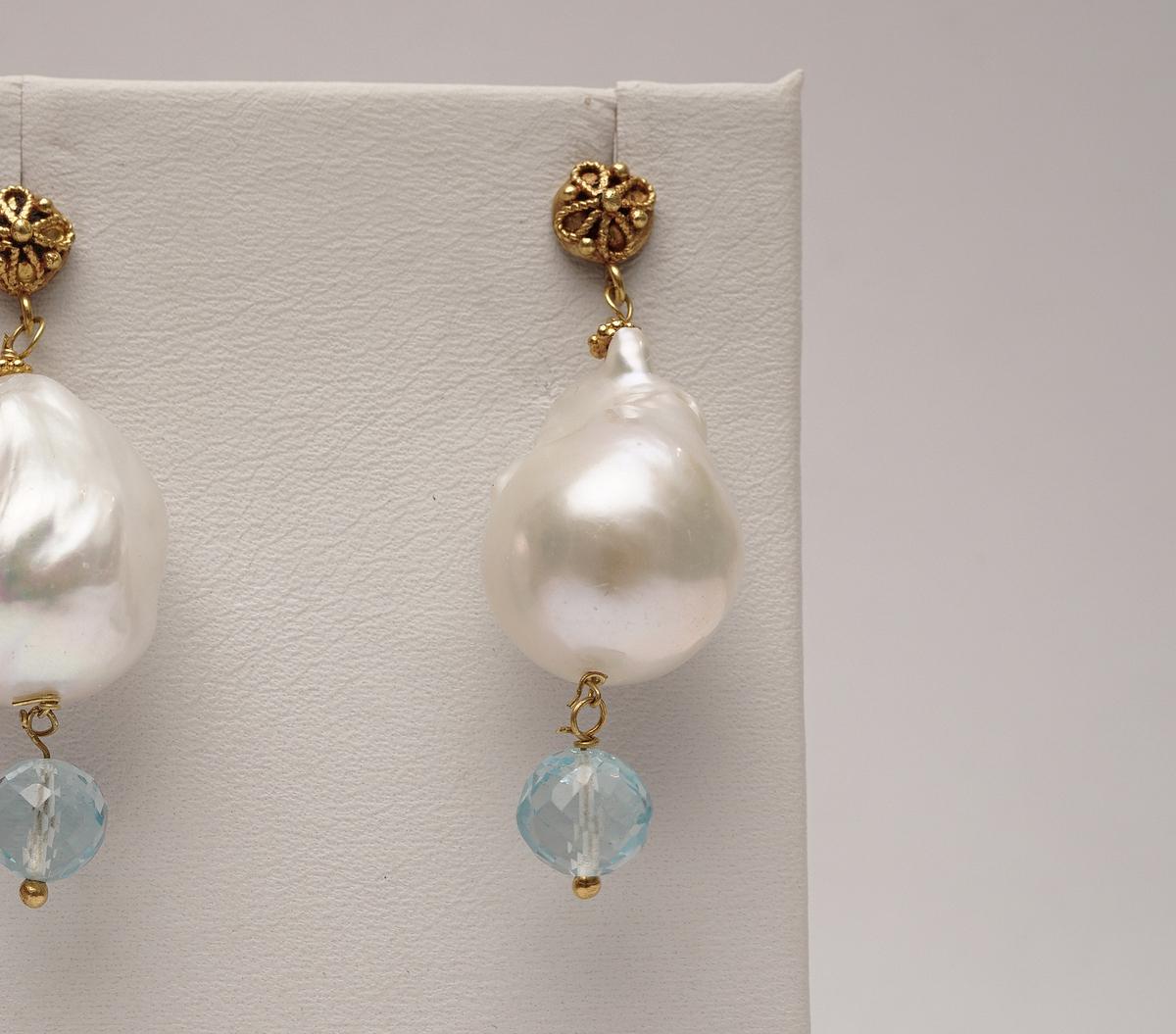 Pair of white baroque pearl dangle earrings with faceted aquamarine drops.  22K gold post for pierced ears.  16mm pearls. Fine granulation work on the post.  By Deborah Lockhart Phillips