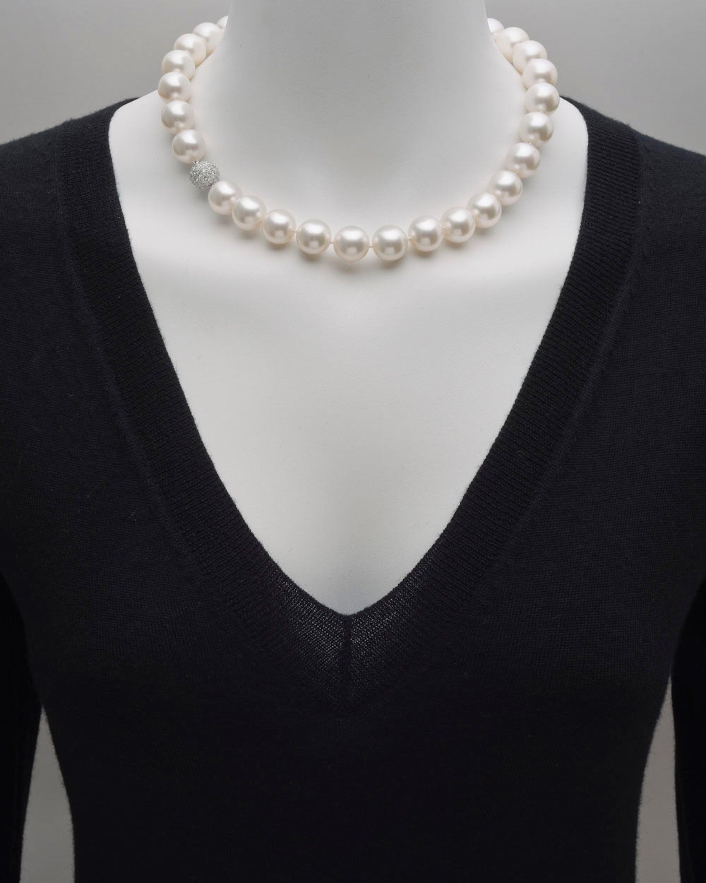 South Sea pearl necklace, composed of 27 South Sea cultured pearls, ranging from 13 to 14mm in diameter, strung on a silk cord, with a pave round-cut diamond ball clasp in platinum measuring approximately 11.4mm in diameter. Diamonds weighing