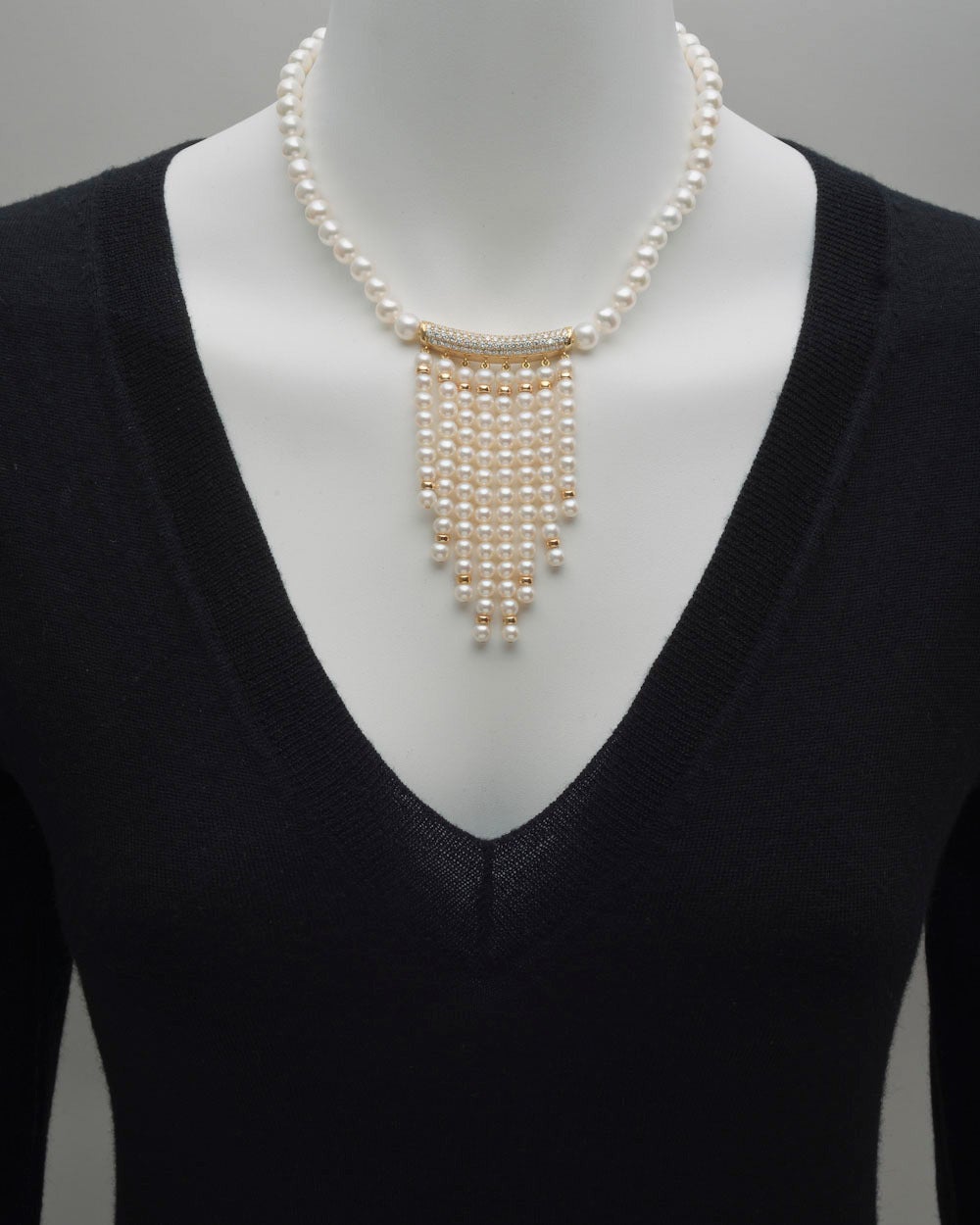 Pearl fringe necklace, designed as a strand of cultured pearls measuring approximately 7 to 8mm in diameter, the strand centering a curved & domed pavé diamond panel in 18k yellow gold, with 76 full-cut round diamonds weighing approximately 1.20