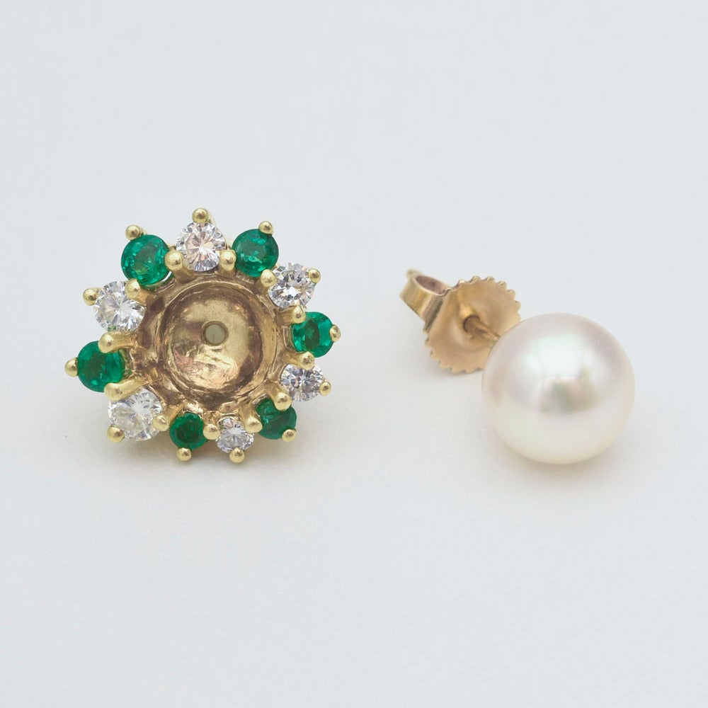 Cultured pearl earstuds with removable emerald and diamond jackets, showcasing two matching pearls measuring approximately 8mm in diameter, the jackets with round emeralds weighing 0.46 total carats and round diamonds weighing 0.65 total carats,