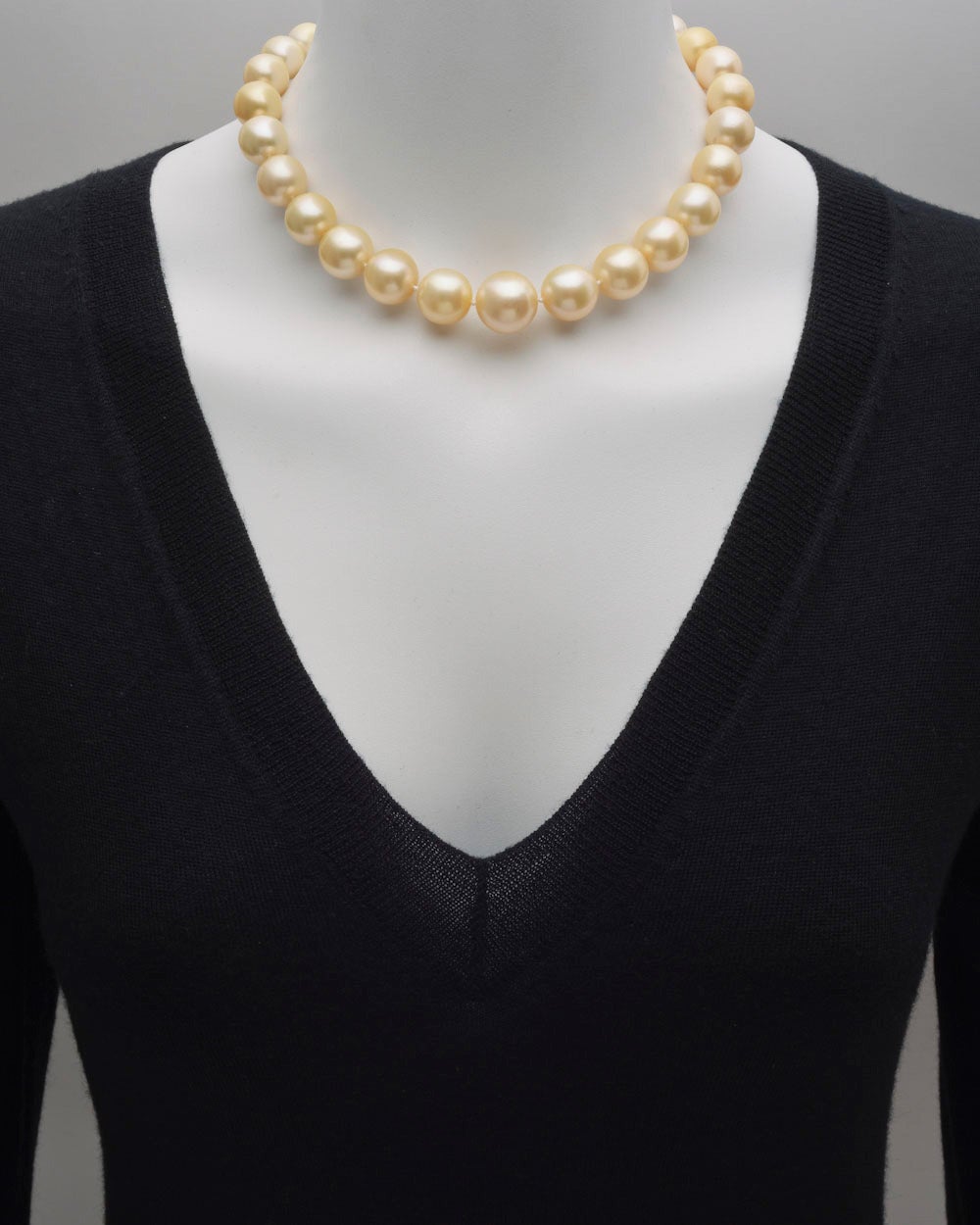 Cultured yellow South Sea pearl necklace, composed of 28 pearls ranging from 11 to 16.5mm in diameter, strung on a hand-knotted silk cord, with a platinum screw-in ball clasp pave-set with round diamonds. 16.5