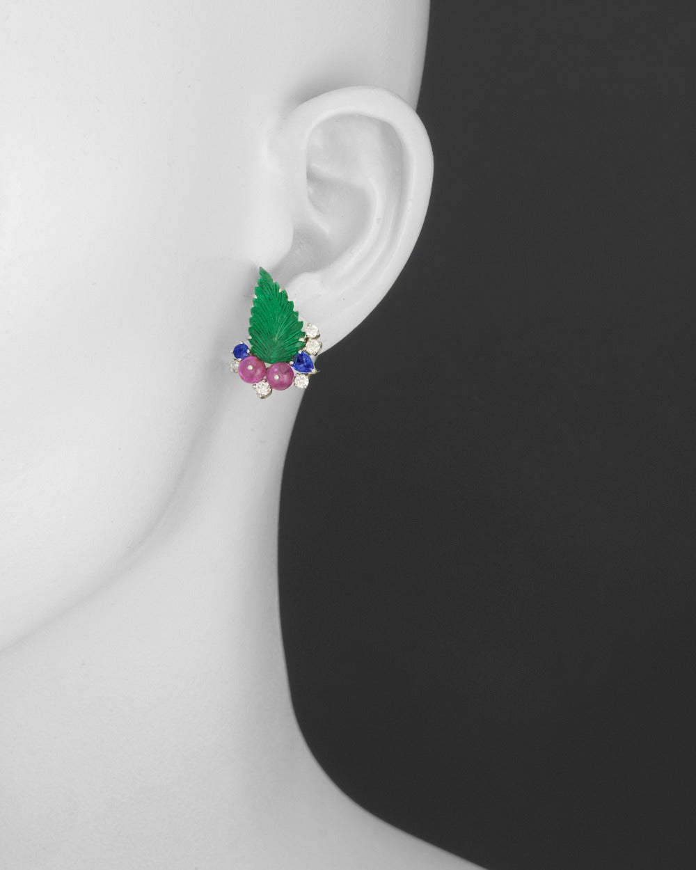 Gemstone leaf earrings, showcasing two emeralds carved in the shape of leaves weighing 7.13 total carats, accented by four ruby beads weighing 3.86 total carats, two pear-shaped sapphires weighing 0.47 total carats, two round-cut sapphires weighing