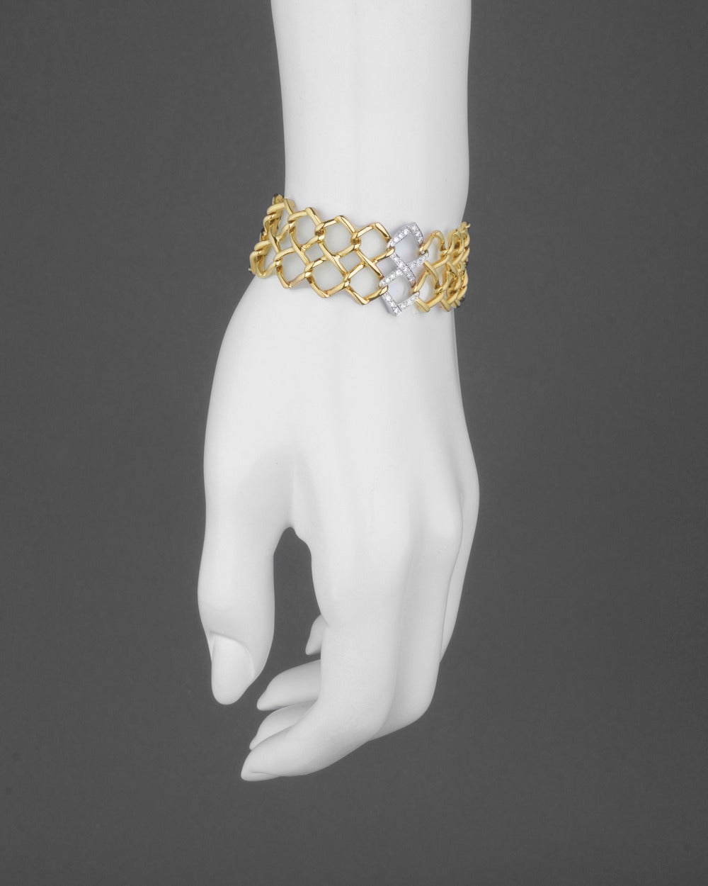 Two row yellow gold lattice bracelet, centering on a diamond-set figure-8 style link in white gold, mounted in 18k gold, circa 1982, signed Paloma Picasso/Tiffany & Co. 6.75