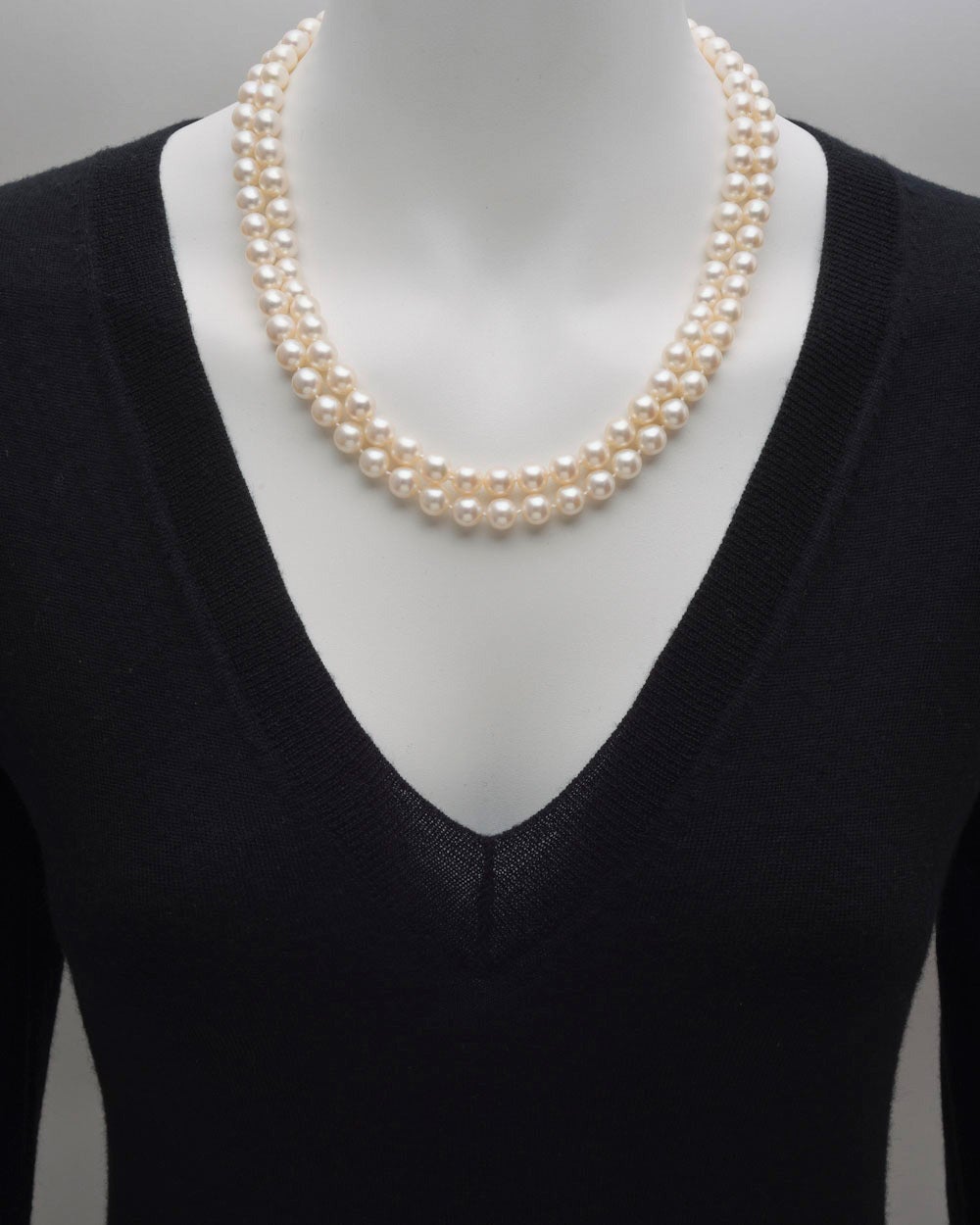 Cultured pearl necklace, composed of two strands of pearls measuring approximately 8mm in diameter, secured by a sapphire and diamond cluster starburst-style clasp in 18k white gold. 20