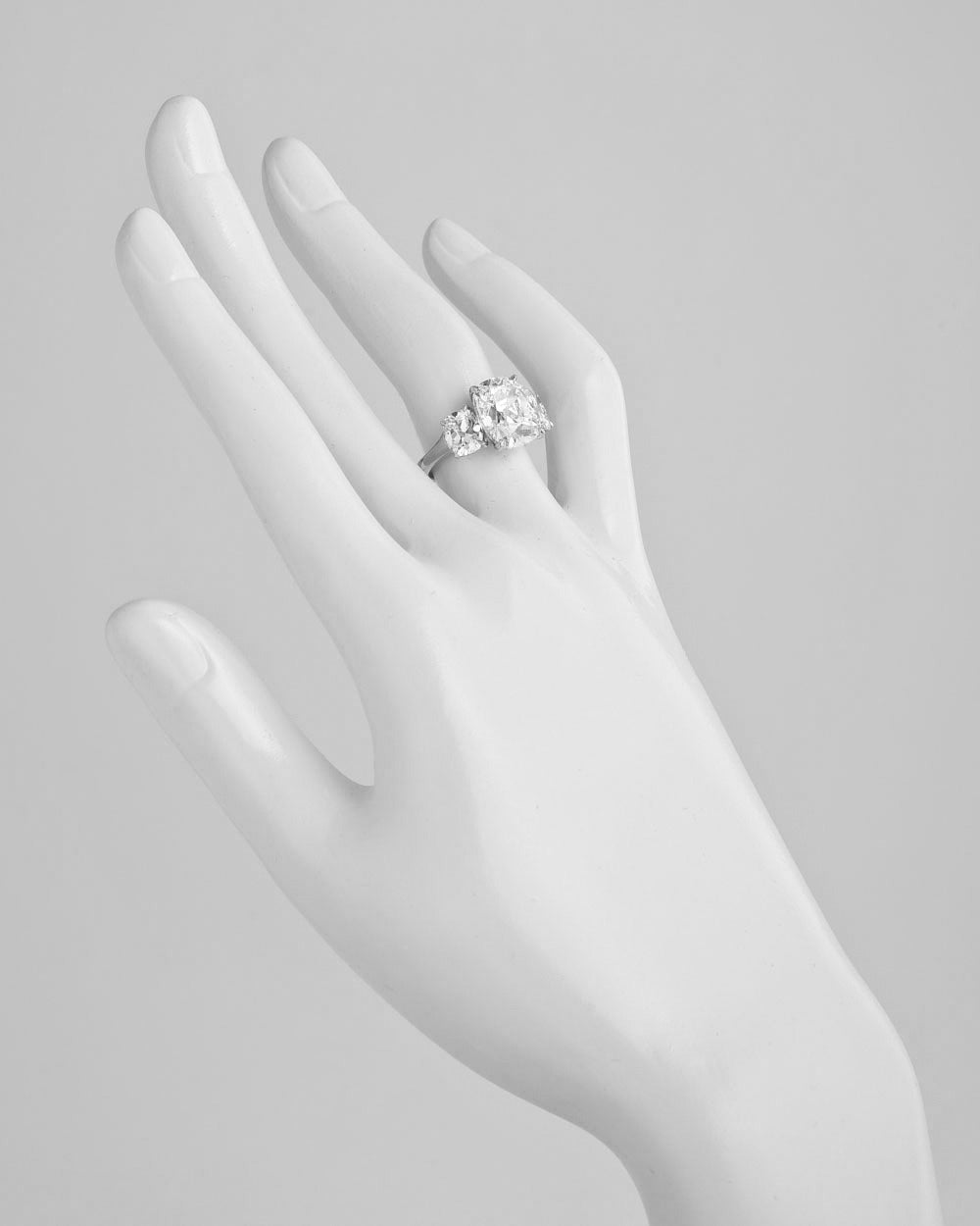 Diamond engagement ring, centering on a colorless cushion-cut diamond weighing 5.04 carats, with two cushion-cut diamond shoulders weighing approximately 1.97 total carats, mounted in platinum. Accompanied by the GIA certificate for the cushion-cut