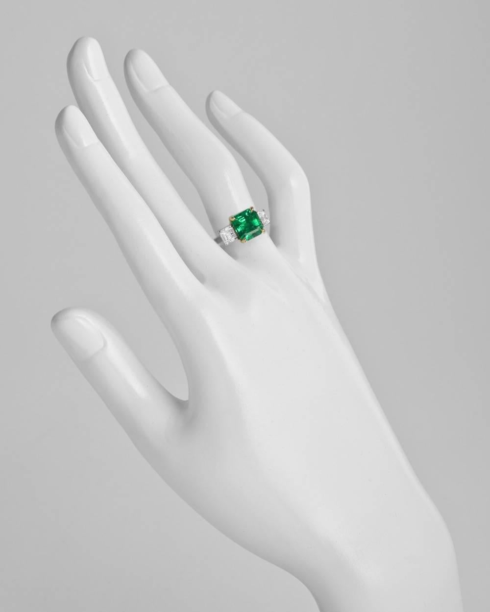 Colombian emerald and diamond ring, centering a fine octagonal-shaped step-cut emerald weighing 2.42 carats, flanked by a pair of colorless asscher-cut diamond shoulders weighing 1.05 total carats (D-E color/VS1-VS2 clarity), mounted in platinum
