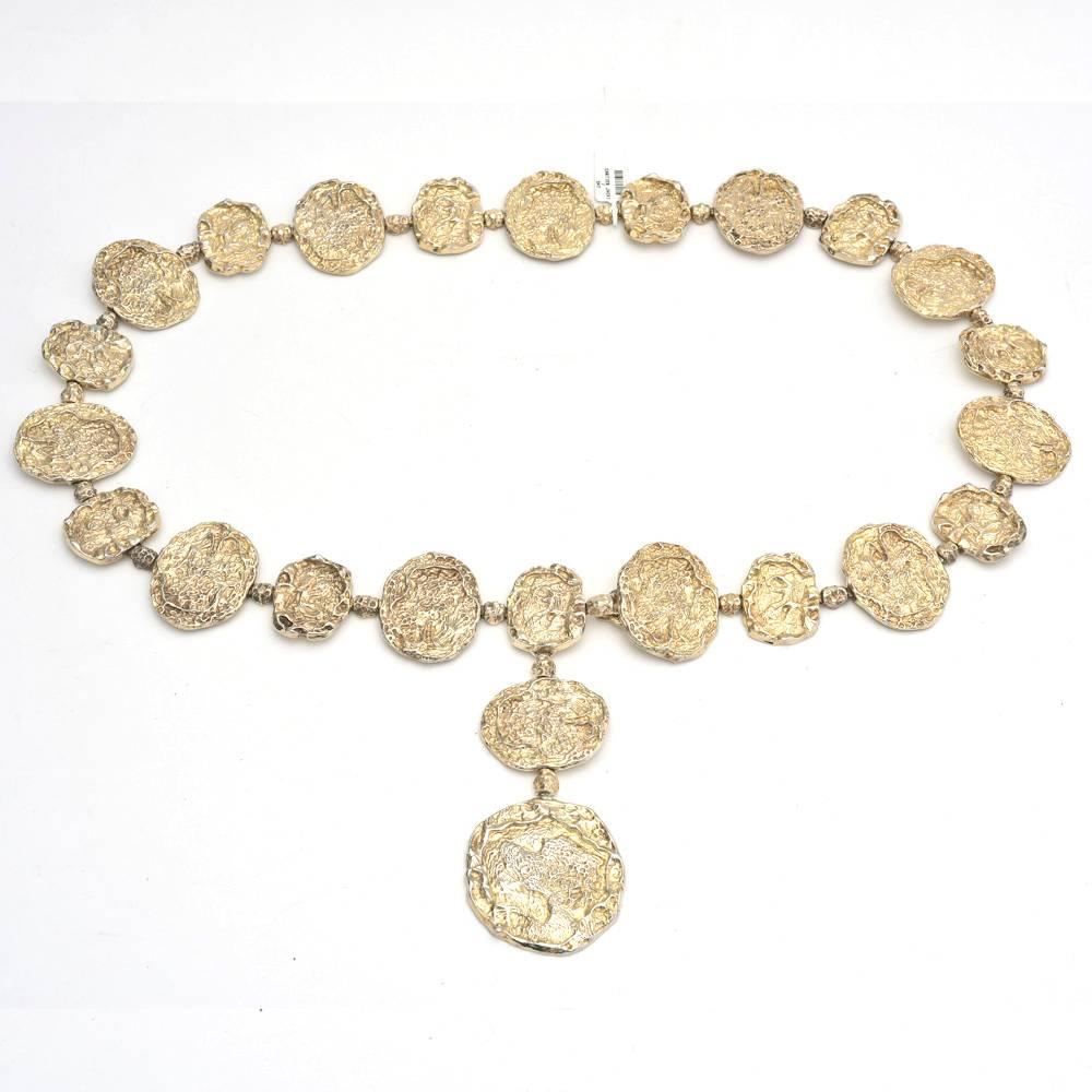 Vermeil mod link belt, composed of multi-sized disc-shaped nugget-style links, in gold-plated sterling silver, circa 1976, signed Cartier. This belt style was made popular in the 1970s by fashion icon Jacqueline Kennedy Onassis. Some wear